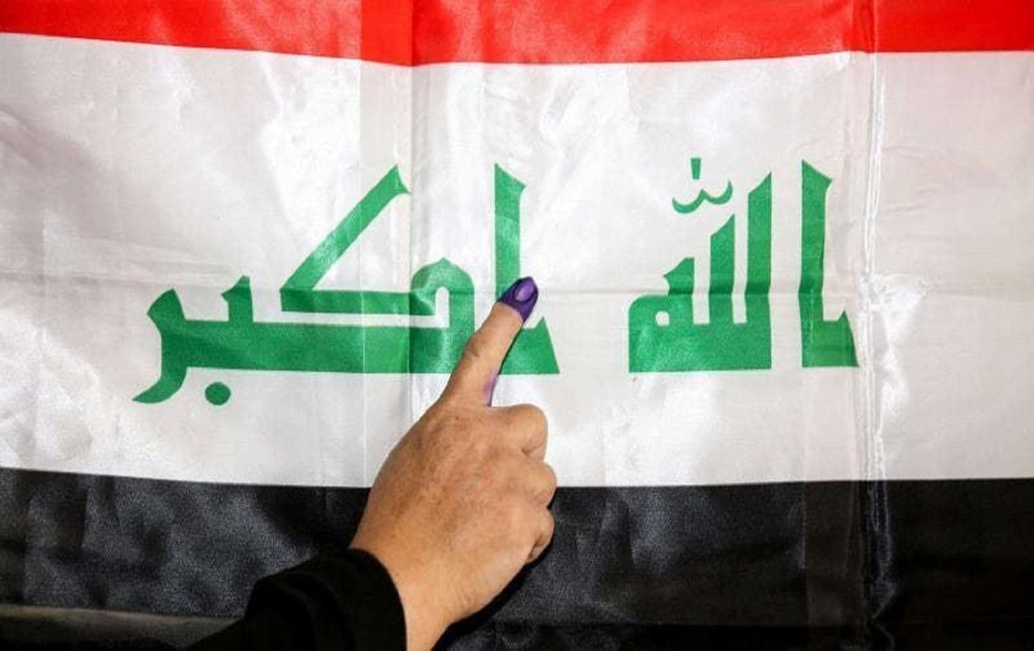 An Iraqi woman holds up an ink-stained finger after voting in the 2018 parliamentary elections in Baghdad. File photo: AFP
