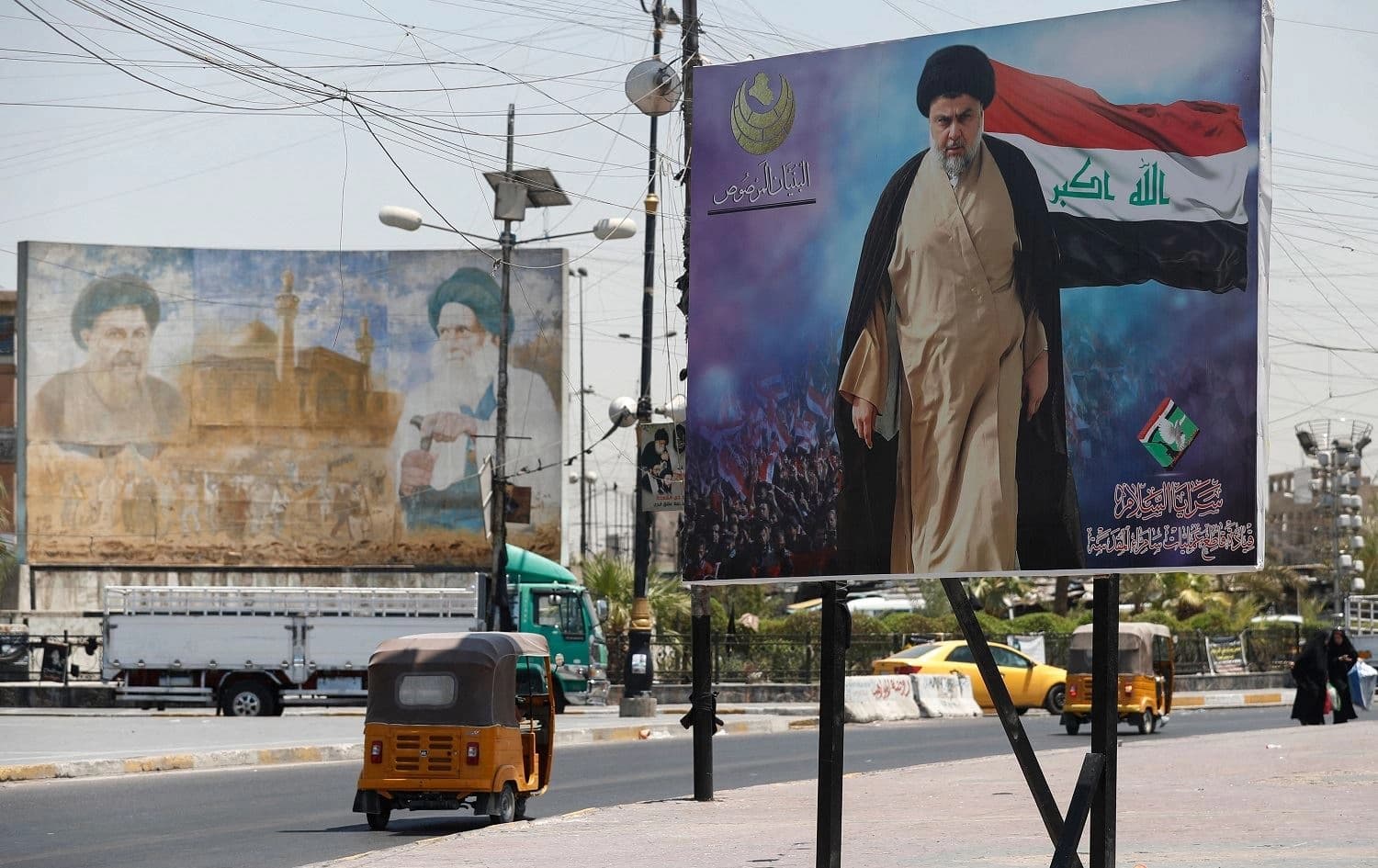 A tuktuk drives past a large poster of Iraq's populist Shiite Muslim cleric Muqtada al-Sadr, in Sadr City, east of Baghdad, on July 15, 2021. Photo: Ahmad al-Rubaye/AFP