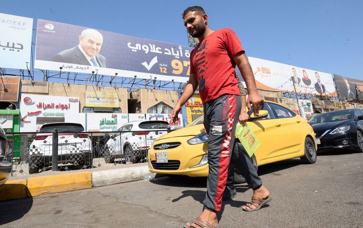An Iraqi man walks past election campaign posters in Baghdad. Photo: Bilind T. Abdullah/Rudaw