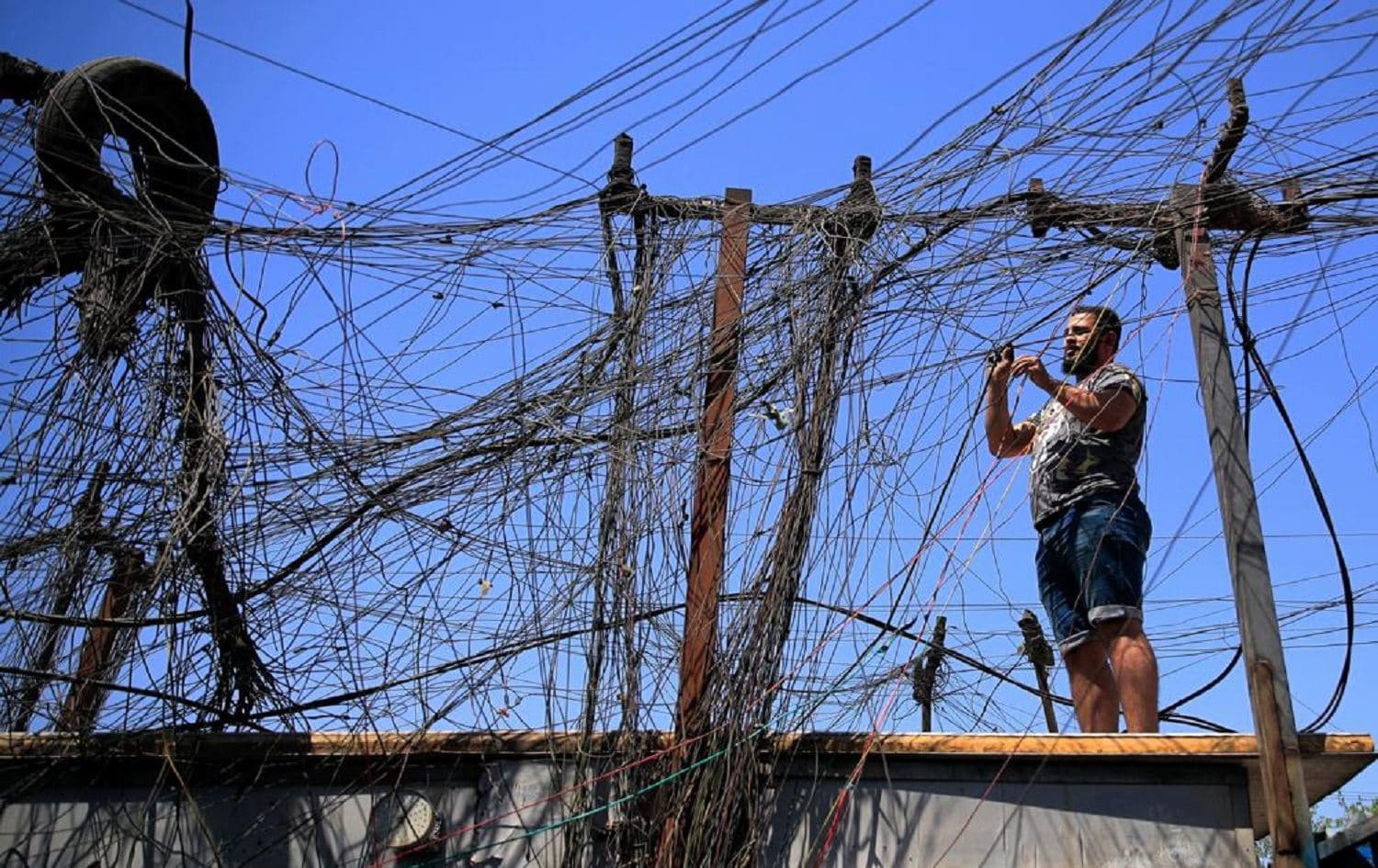 Muqtada Haider turns the switches to transfer electricity to private homes in Baghdad, Iraq, Friday, Sept. 10, 2021. In Iraq, electricity is a potent symbol of endemic corruption, rooted in the country’s sectarian power-sharing system. This contributes to chronic electrical outages of up to 14 hours a day in a major oil-producing nation with plentiful energy resources. Photo: Hadi Mizban/ AP