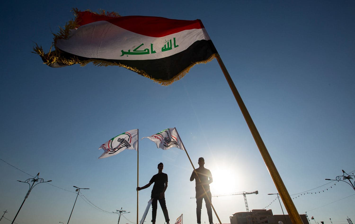 Supporters of Hashed al-Shaabi, an Iraqi paramilitary network dominated by Iran-backed factions, wave the Hashed flag in the southern Iraqi city of Basra on October 17, 2020. Photo: Hussein Faleh/ AFP