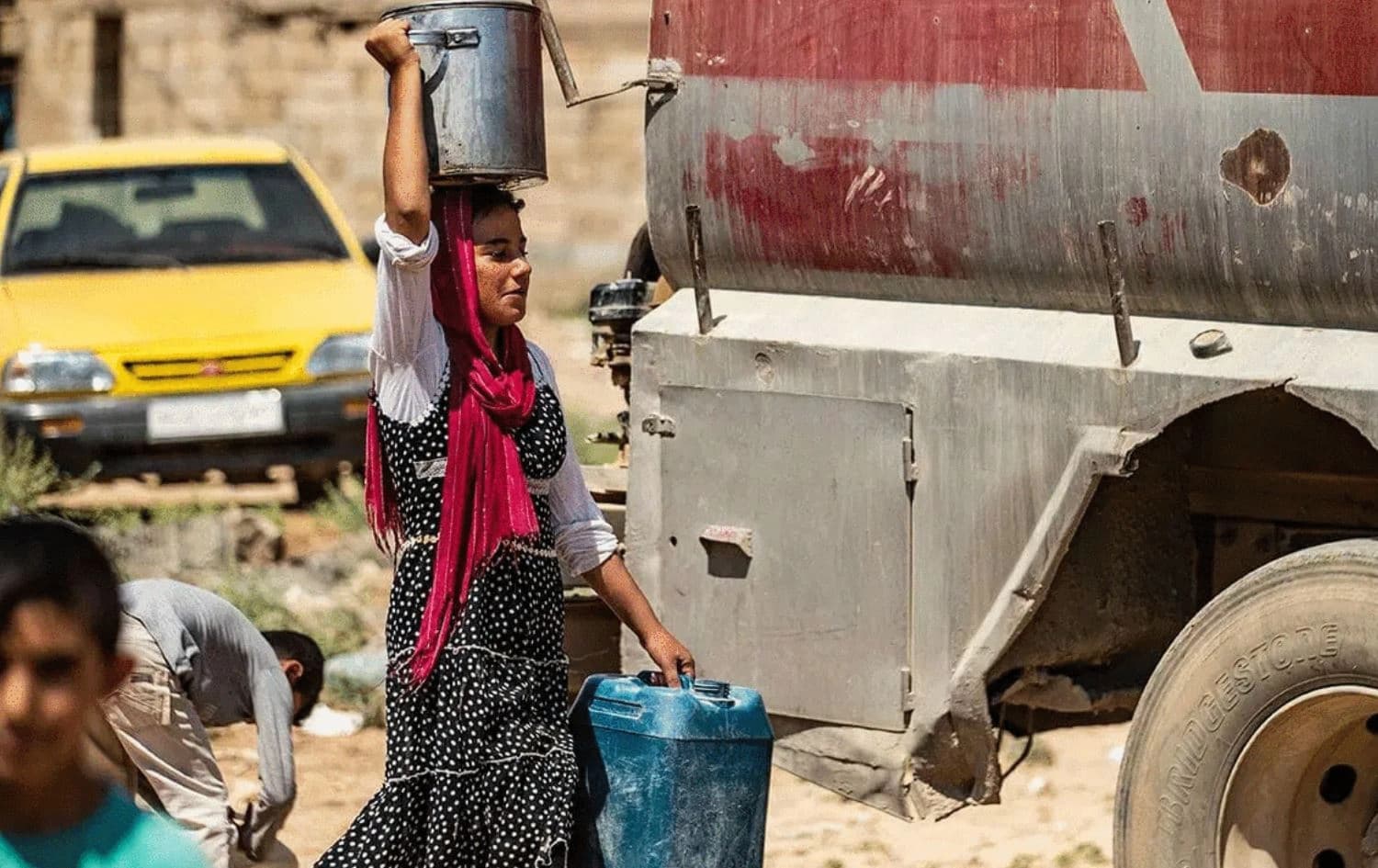 A Syrian girl carries a pot filled with water from cisterns provided by humanitarian organisations during a water outage in Syria's northeastern city of Hasakah on August 22, 2020. Photo: AFP