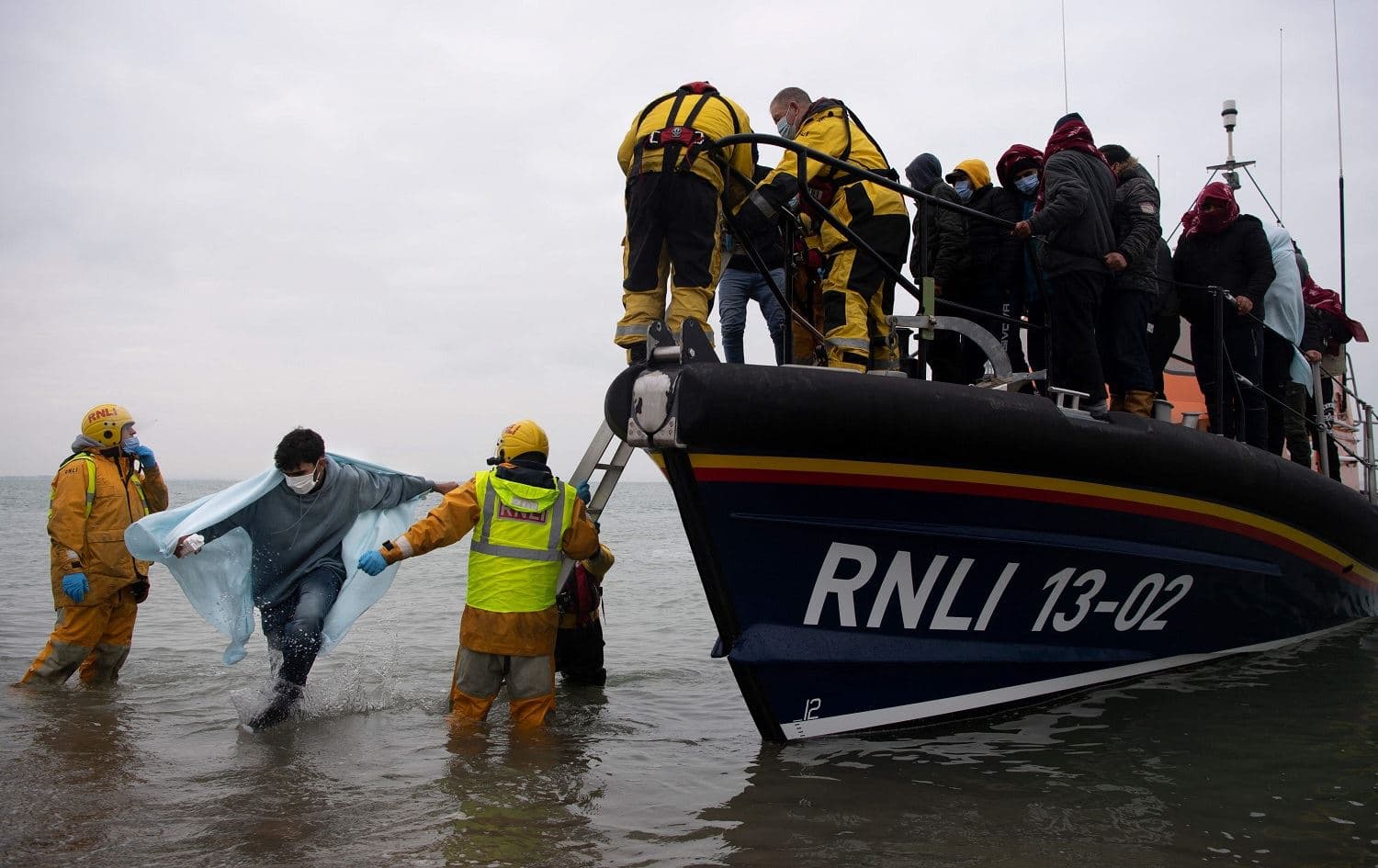 Migrants are helped ashore from a RNLI (Royal National Lifeboat Institution) lifeboat at a beach in Dungeness, on the south-east coast of England, on November 24, 2021, after being rescued while crossing the English Channel. Photo: Ben Stansall/AFP