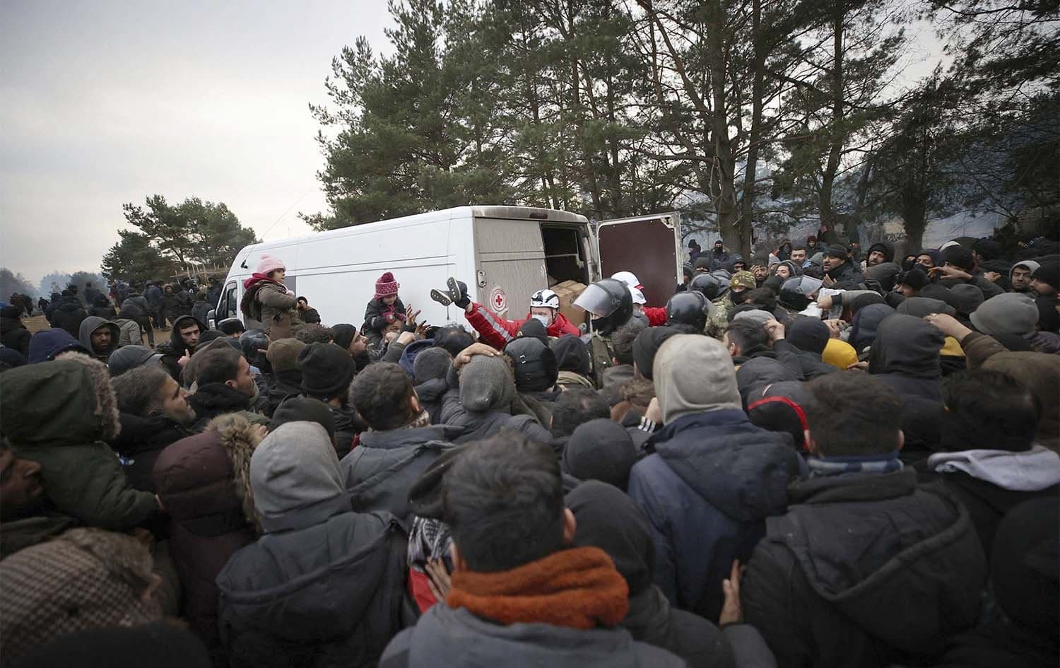A group of migrants gather to receive humanitarian aid in a camp near the Belarusian-Polish border in the Grodno region on November 13, 2021. Photo: AFP 