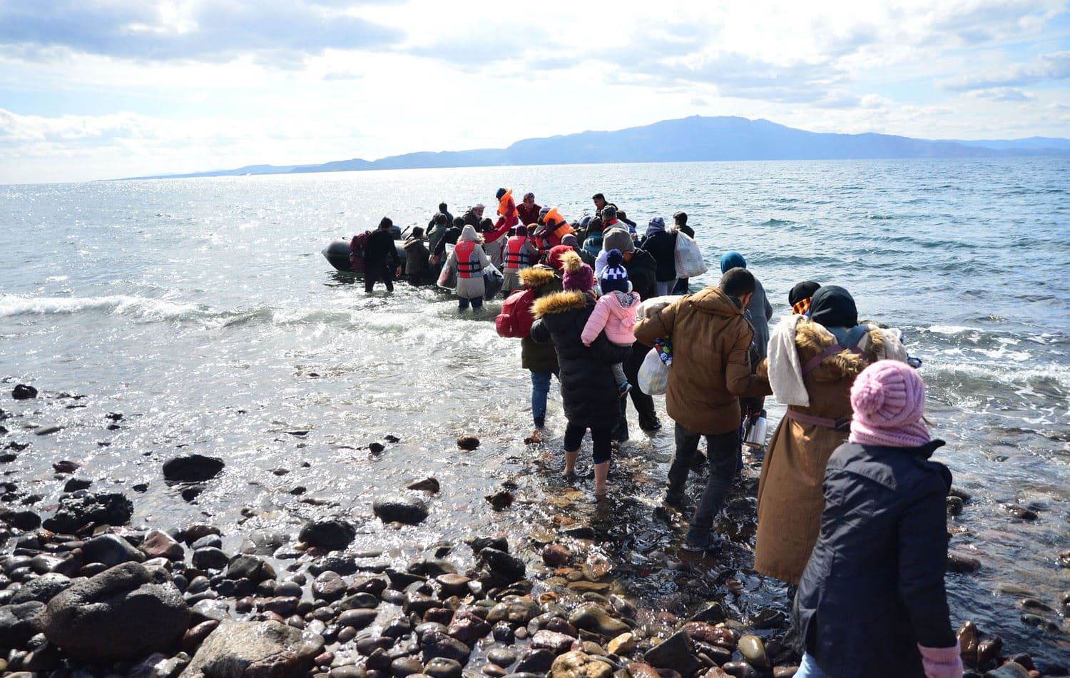 Migrants board a small inflatable boat on the Turkish coast in Canakkale province, across part of the Aegean Sea from the Greek island of Lesbos, on February 28, 2020. Anadolu Agency