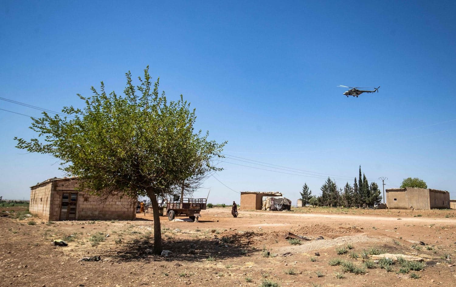 A military helicopter hovers above houses in the al-Darbasiyah town in northeastern Hasaka province on July 14, 2021. Photo: Delil Souleiman/AFP 