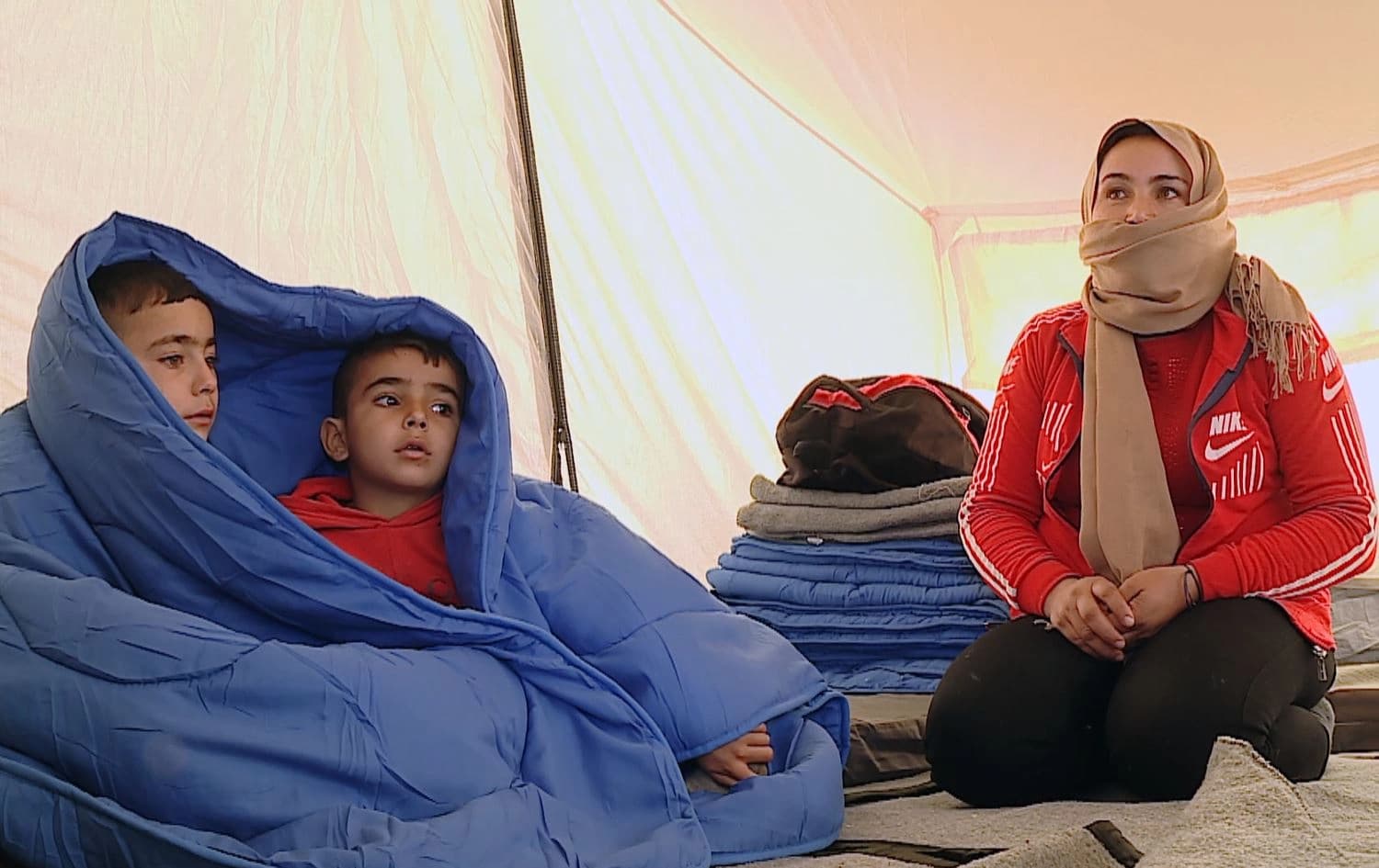 Newly-arrived Rojava refugees warm themselves with blankets. Date: January 18, 2022. Photo: Rudaw