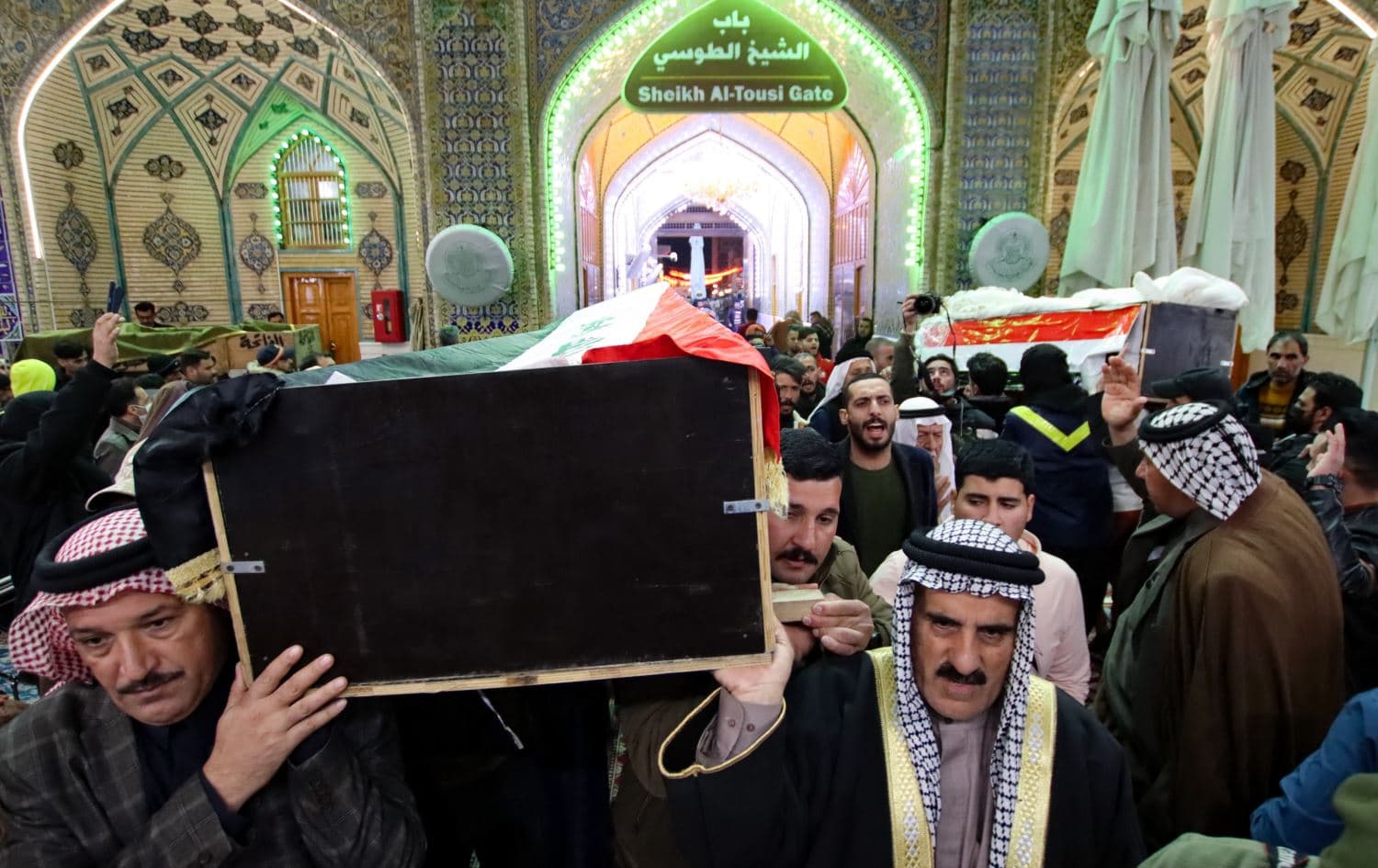 Mourners carry the caskets of two of eleven Iraqi soldiers, killed in an overnight attack by ISIS in eastern Iraq on January 21, 2022. Photo: AFP  