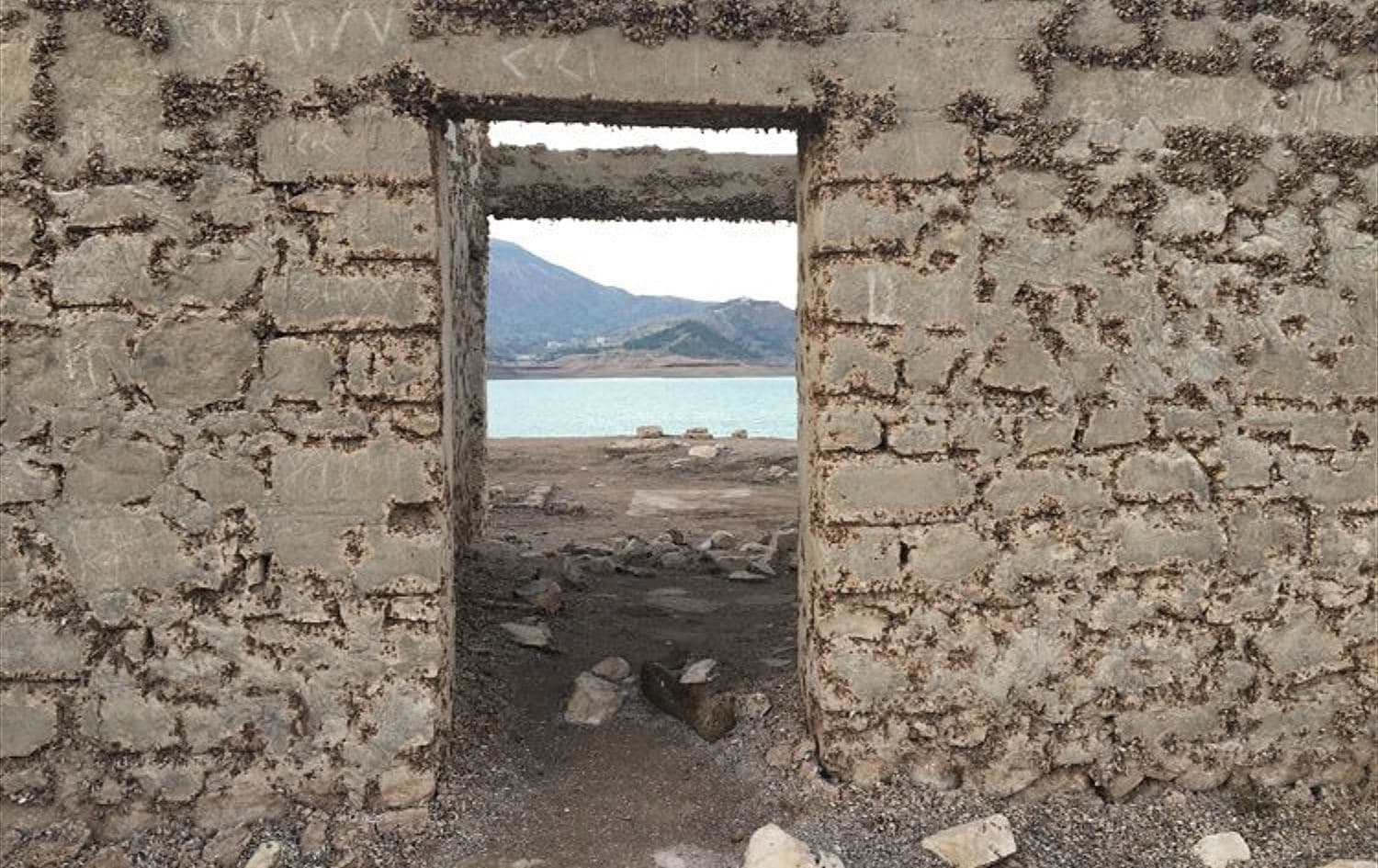 Duhok dam's depleting water levels, in the Kurdistan Region's Duhok province, taken in December 2021. The water is low enough that you can walk across and enter a previously submerged school. Photo: Alannah Travers/Rudaw