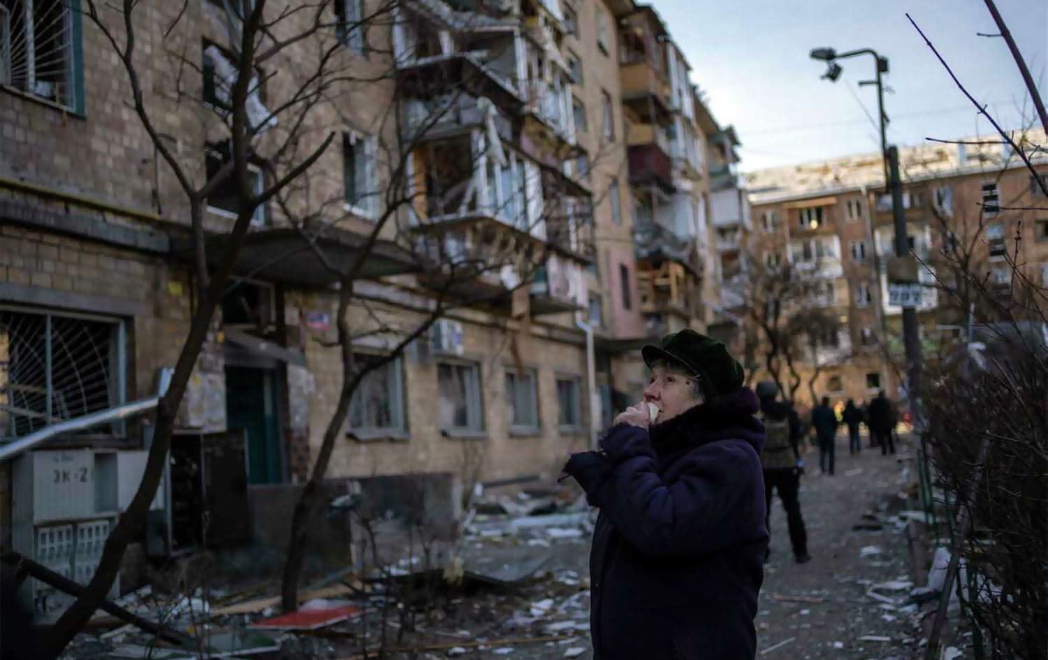 A woman looks at residential buildings damaged by a bomb in Kyiv, Ukraine, on March 18, 2022. Photo: AP