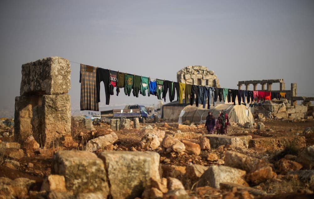 Syrian displaced people walk next to ancient Roman ruins in Sarmada district, north of Idlib city, Syria on November 25, 2021. Photo: Francisco Seco/AP