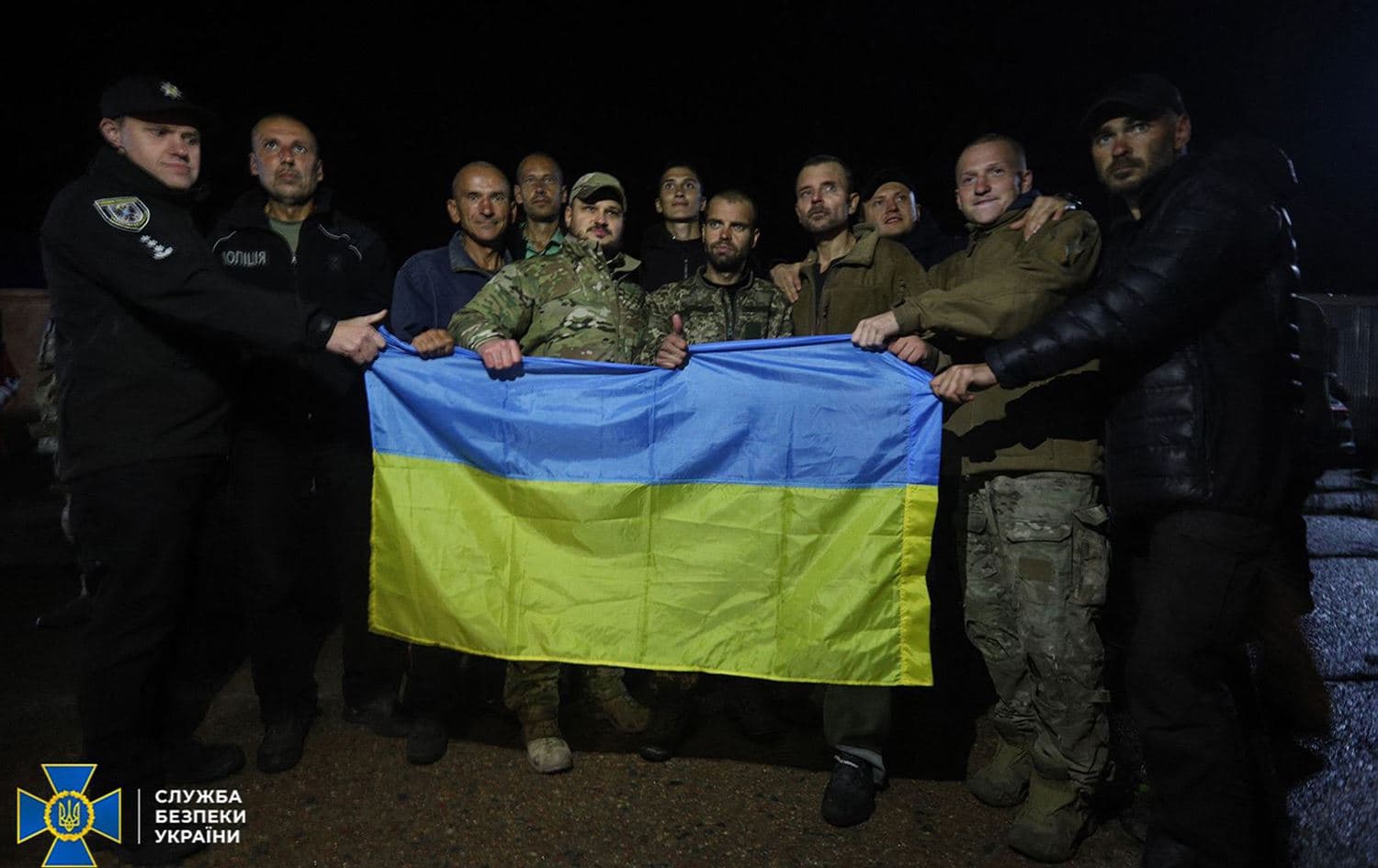 This handout photograph taken and released by Security Service of Ukraine on September 22, 2022 shows Ukrainian prisoners of war posing with a Ukrainian flag after their exchange in Chernigiv region. Photo: Handout/AFP