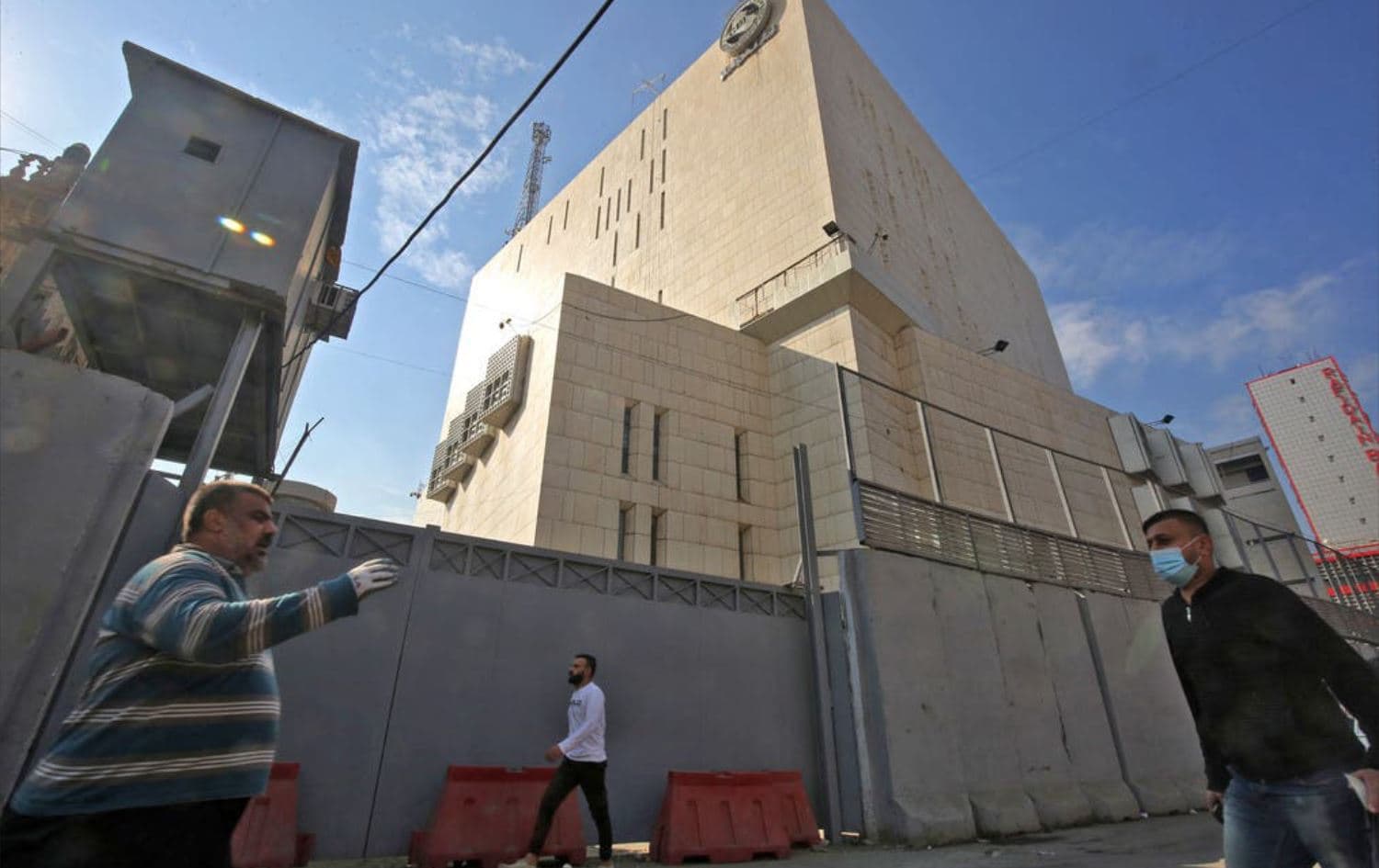 Iraqis walk past the Central Bank of Iraq's headquarters on Rashid Street in the Baghdad, on December 22, 2020. Photo: AFP