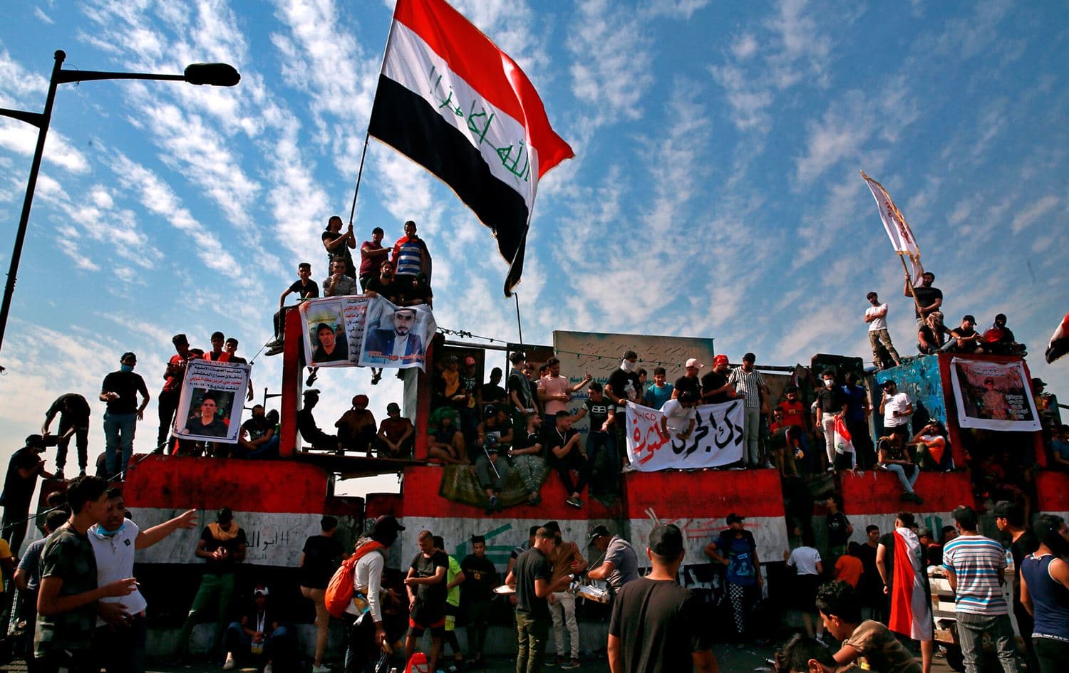 Anti-government protesters gather on the closed Jumhuriya Bridge that leads to the Green Zone government areas in Baghdad, Iraq, October 25, 2020. Photo: Khalid Mohammed/AP