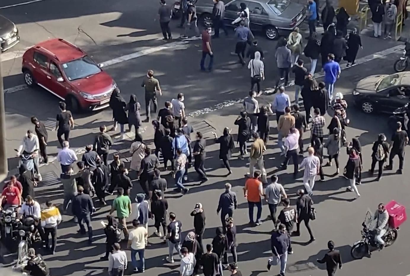 People block an intersection during a protest to mark 40 days since the death in custody of 22-year-old Mahsa Amini, whose tragedy sparked Iran's biggest antigovernment movement in over a decade, in Tehran, Iran, Wednesday, Oct. 26, 2022. Photo: via AP