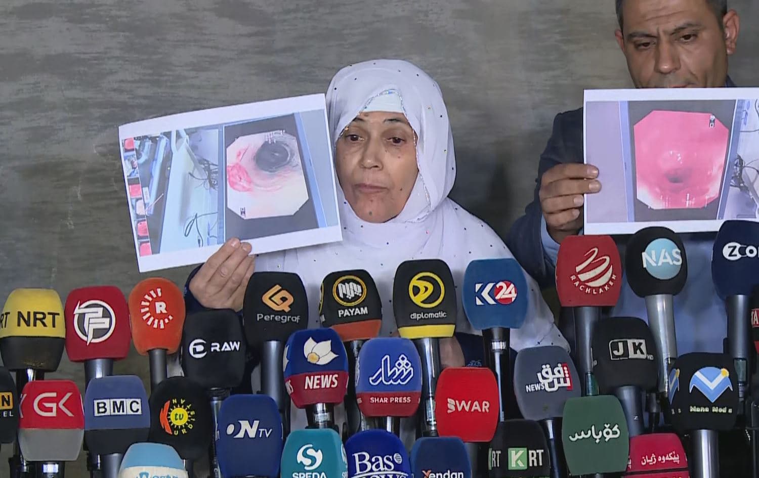 Akhtar Ahmad, Kazim Faruq’s mother, holding up a medical report during a press conference in Sulaimani on October 30, 2022. Photo: Rudaw