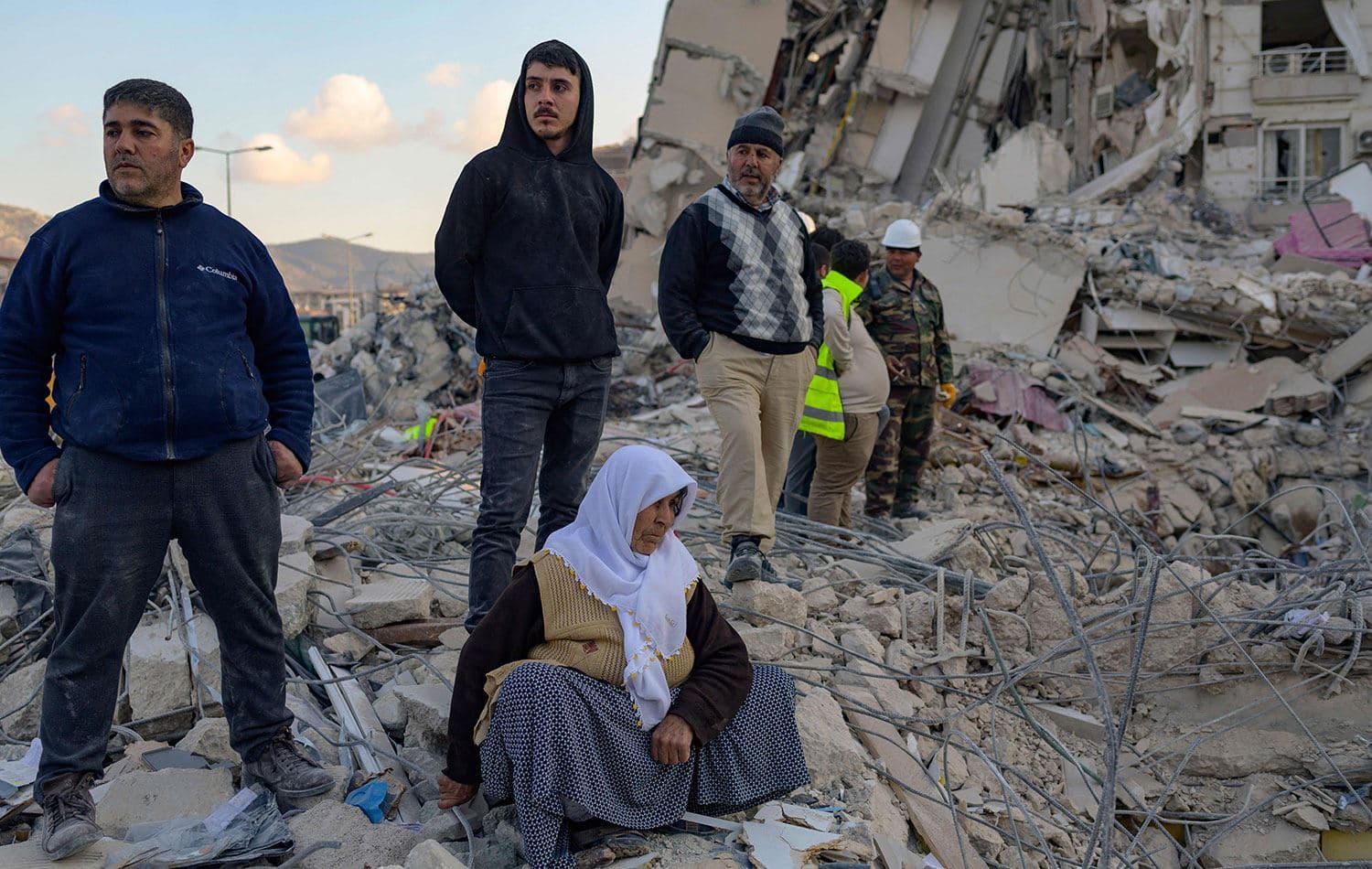 19 Şubat 2023'te Hatay'da çöken binanın enkazından yakınlarının çıkarılmasını bekleyen bir kadın. / (Fotoğraf: Yasin AKGÜL / AFP)