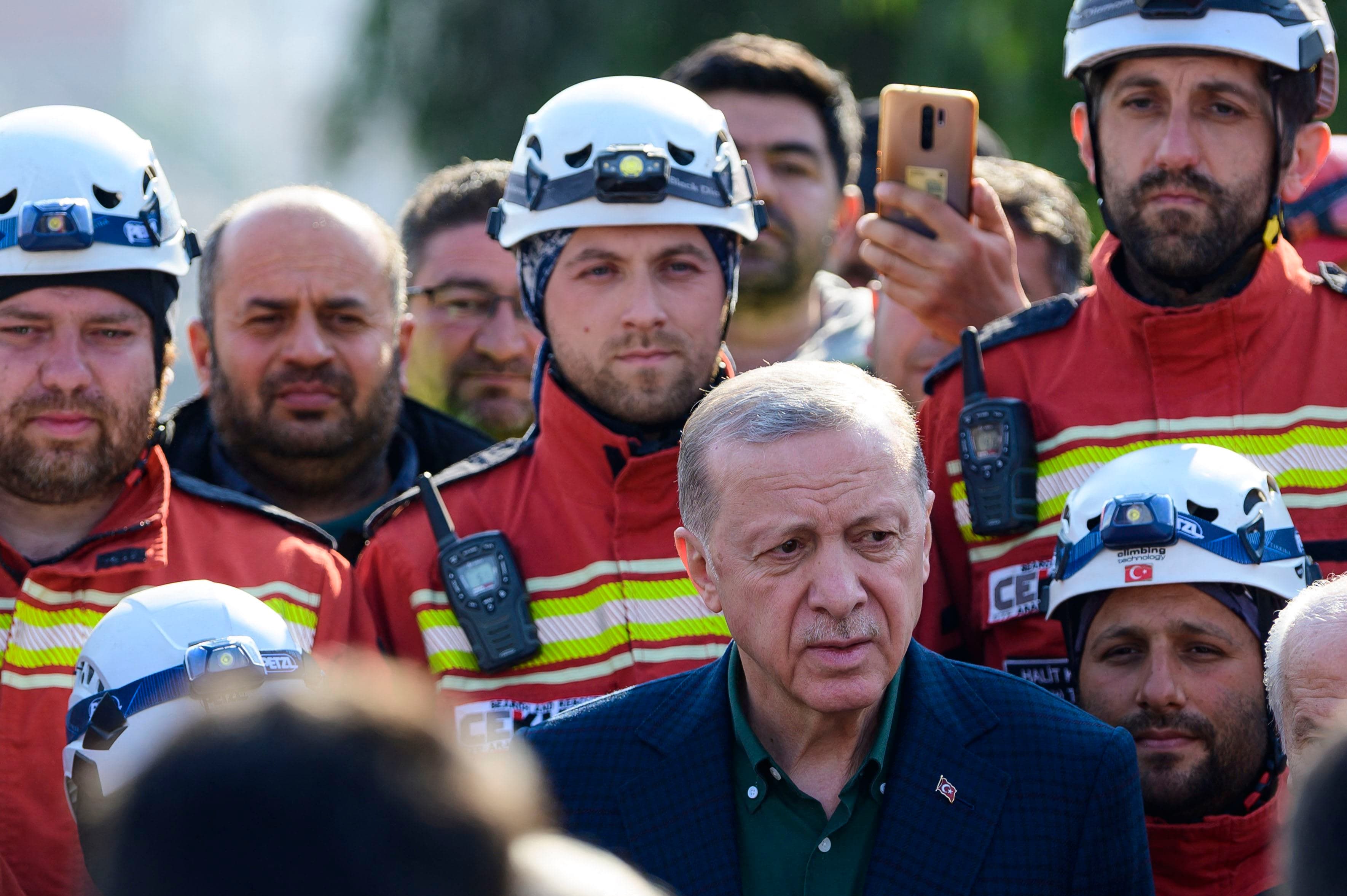 Turkish President Recep Tayyip Erdogan stands with rescue workers as he visits the hard-hit southeastern province of Hatay following two earthquakes on February 20, 2023. Photo: AFP
