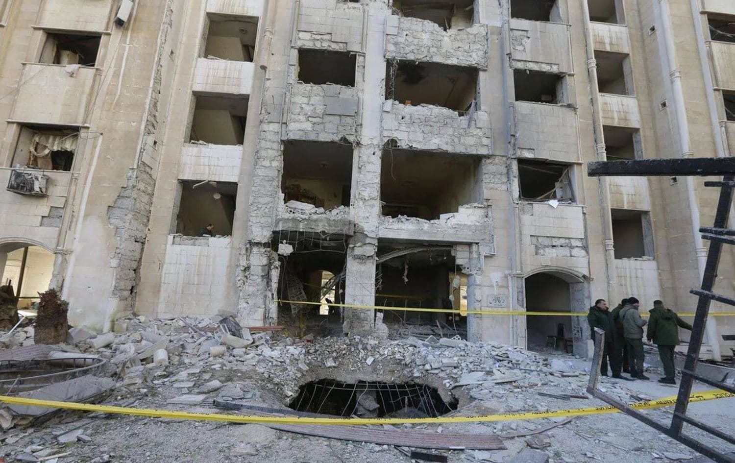 Members of the Syrian security forces gather in front of a building damaged in a reported Israeli missile strike in Damascus. Photo: Louai Beshara/AFP