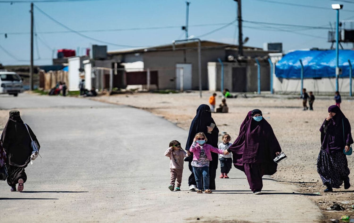 Women with children walk at Roj camp, where relatives of people suspected of belonging to the Islamic State are held in Hasaka province, northeast Syria on March 28, 2021. Photo: Delil Souleiman/AFP