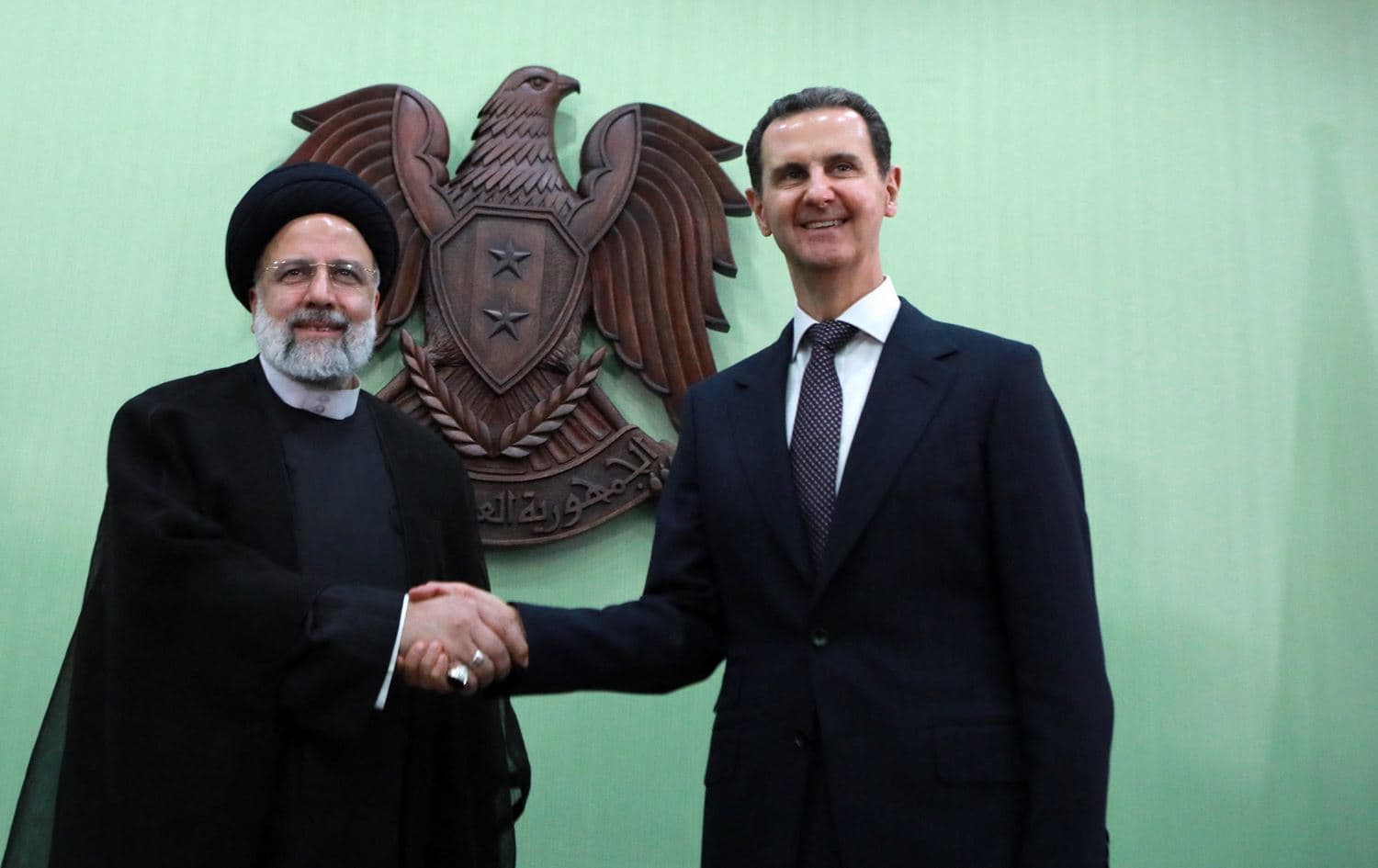 Syria's President Bashar al-Assad (right) shakes hands with his Iranian counterpart Ebrahim Raisi (left) in Damascus on May 3, 2023. Photo: Louai Beshara/AFP
