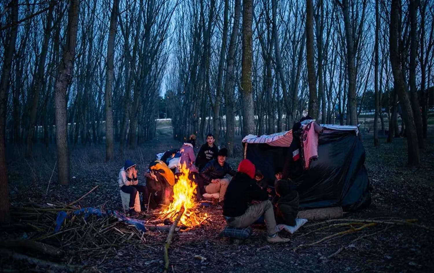 A group of migrants rest at a fire as they wait to cross the Maritsa river to reach Greece at the Turkish-Greek border, in Edirne, in northwestern Turkey, on March 1, 2020. Photo: AFP