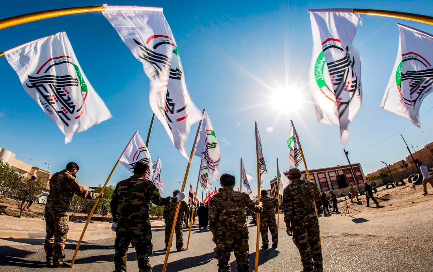 Members of Iraq’s Popular Mobilization Forces (PMF) march with the group’s flag during in the city of Basra on May 21, 2019. Photo: Hussein Faleh/AFP