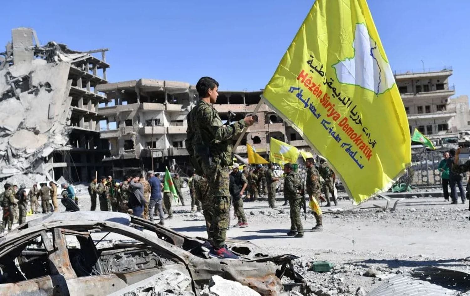 A member of the SDF holding their flag in Syria in October 2017. Photo: AFP