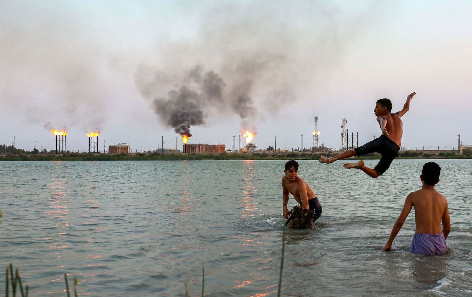 Iraqi youths swim in the Shatt al-Arab waterway at the end of a hot summer day in the southern Iraqi city of Basra on August 11, 2023. Photo: Hussein Faleh/AFP