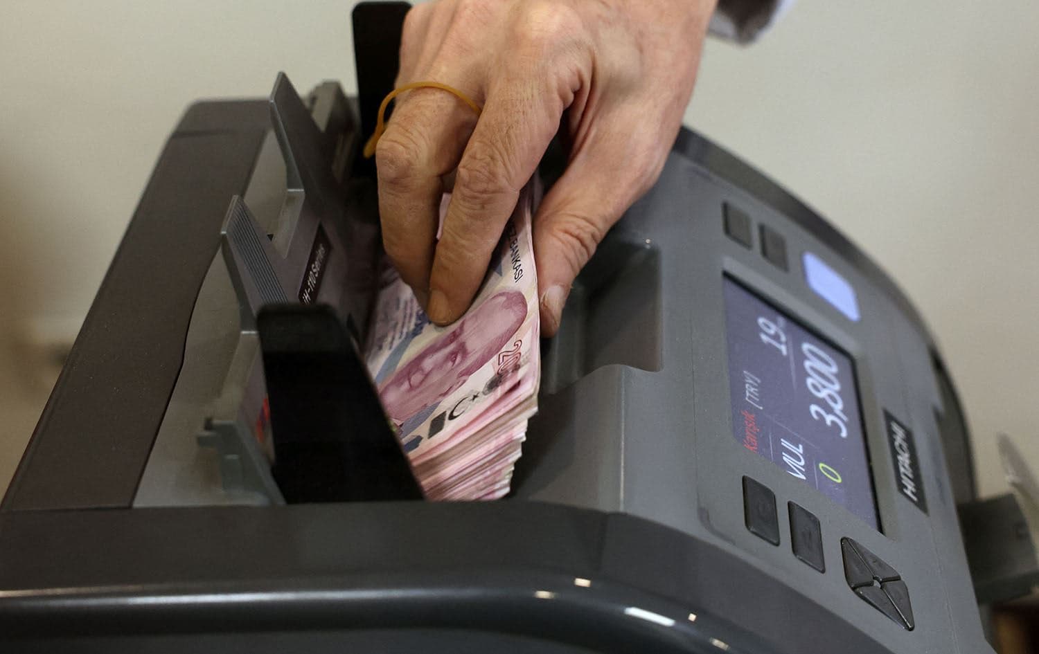 A teller uses a machine to count Turkish lira banknotes at a foreign exchange office in Ankara on July 20, 2023. Photo: Adem Altan/AFP