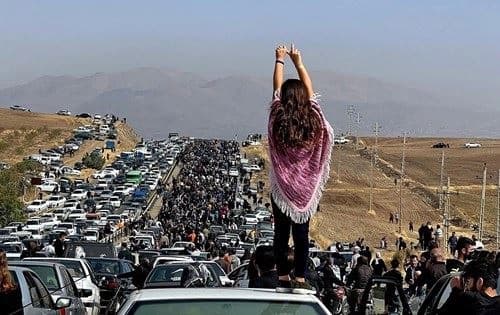 An unveiled woman stands on top of a vehicle on October 26, 2022 as thousands make their way towards Aichi cemetery in Saqqez, Iran where Zhina (Mahsa) Amini is buried. File photo: UGC/AFP