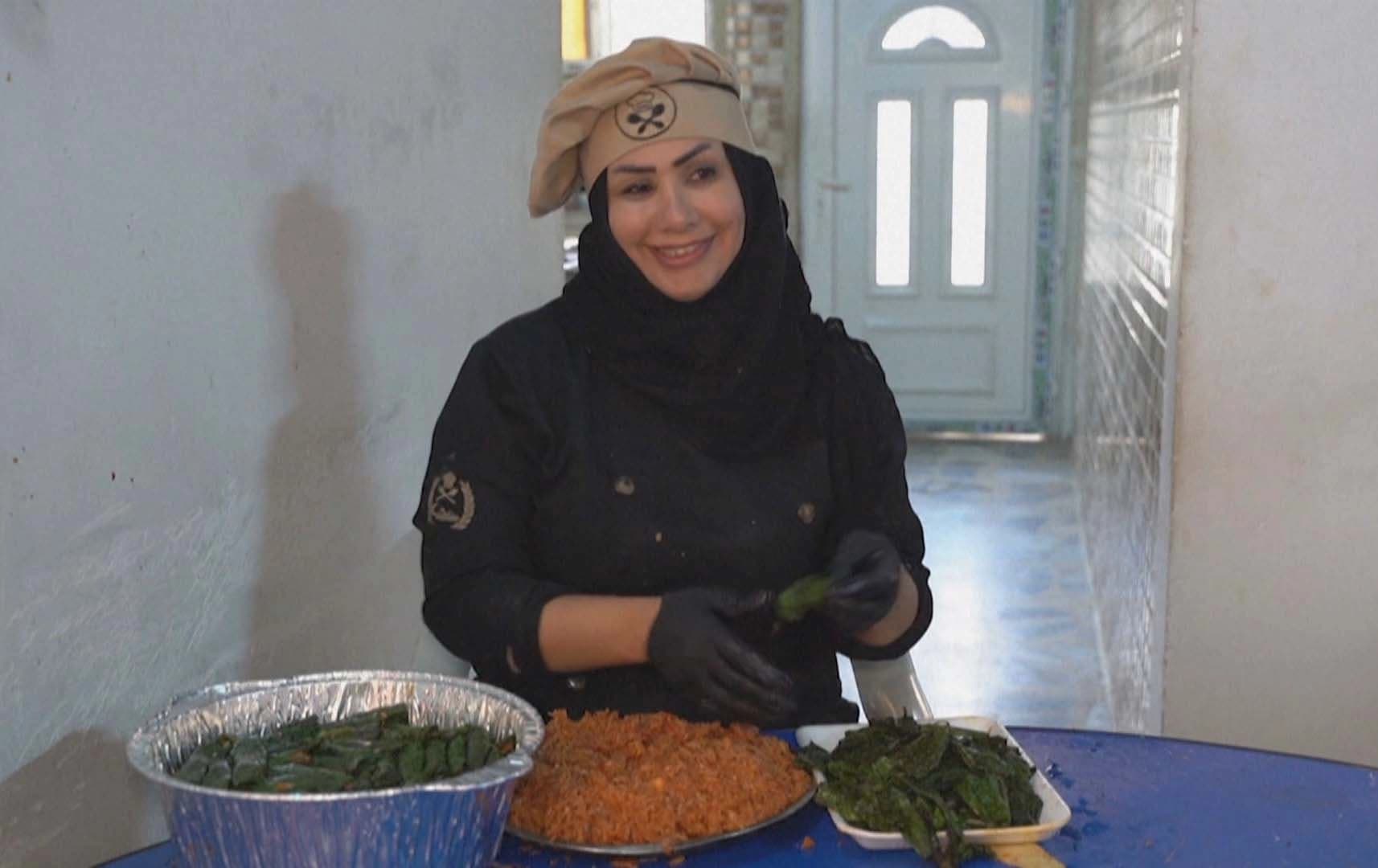 چێشتلێنەرێک لە چێشتخانەکە خۆراک ئامادە دەکات