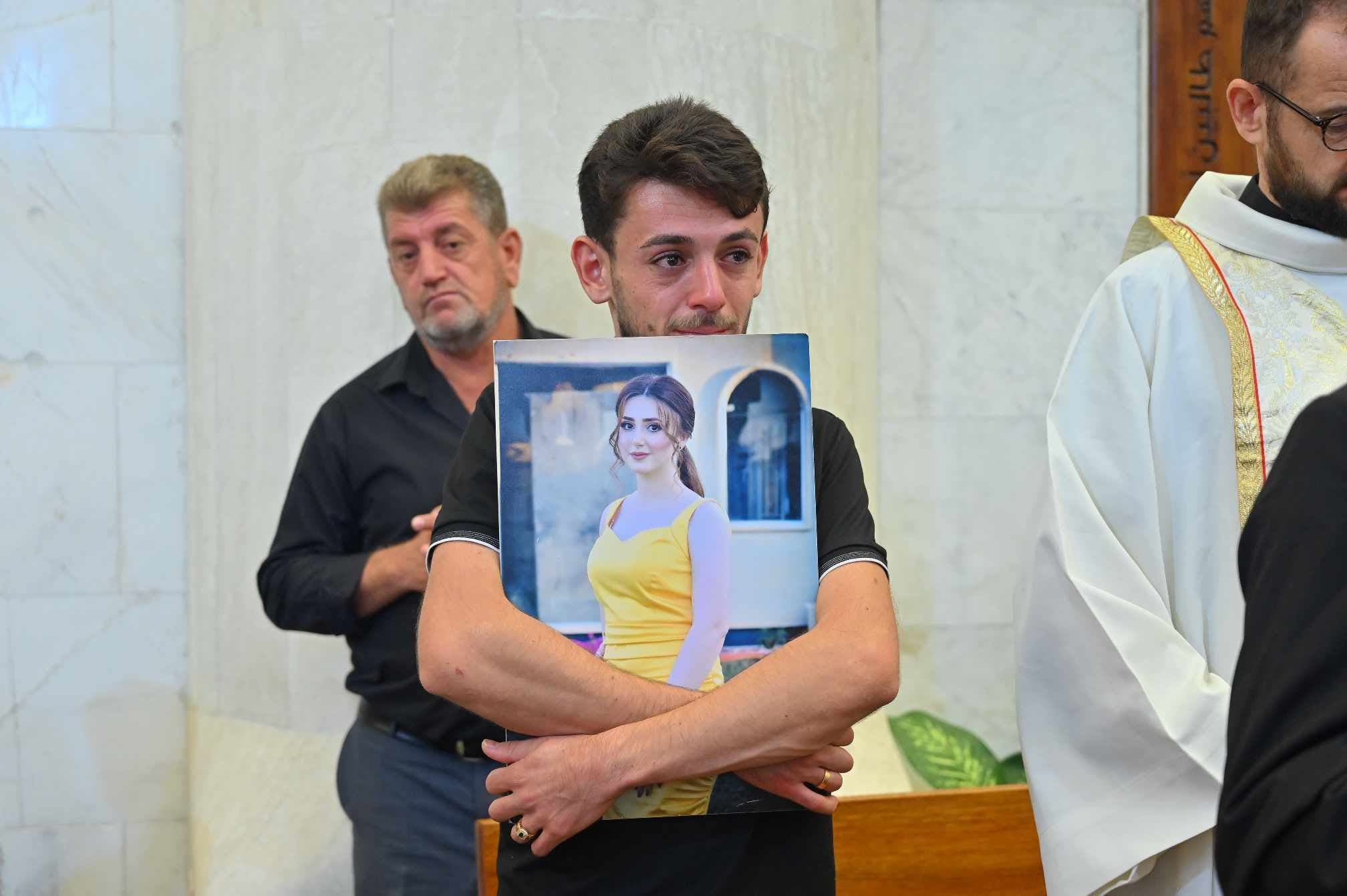 Steven embraces the portrait of his fiancee during her wake in Hamdaniya on September 28, 2023. Photo: Bilind T. Abdullah/Rudaw