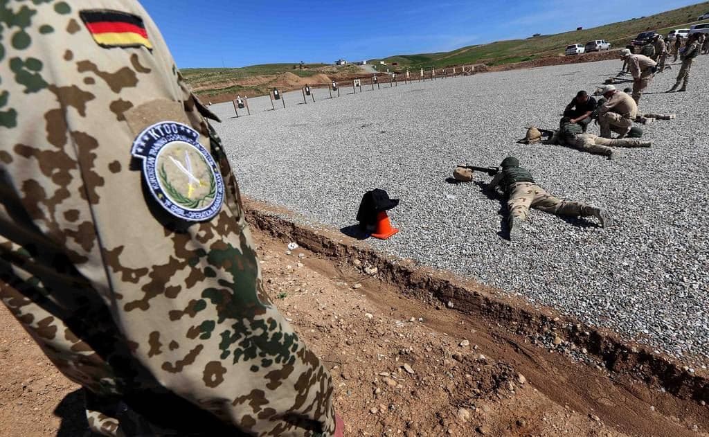 A German military trainers looks are Peshmerga fighters shooting during a training session in Erbil in 2016. Photo: AFP