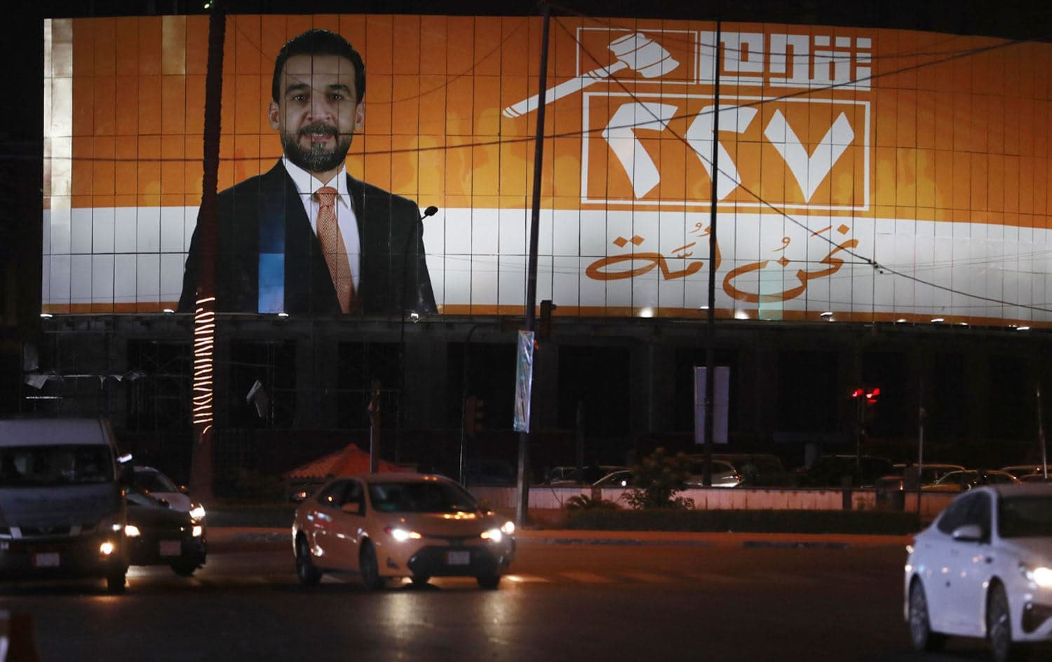A large neon campaign sign showing ousted Iraqi Parliament Speaker Mohammed al-Halbousi, who is running in the local elections in December, lights up the side of a building, in Baghdad on November 14, 2023. Photo: AFP
