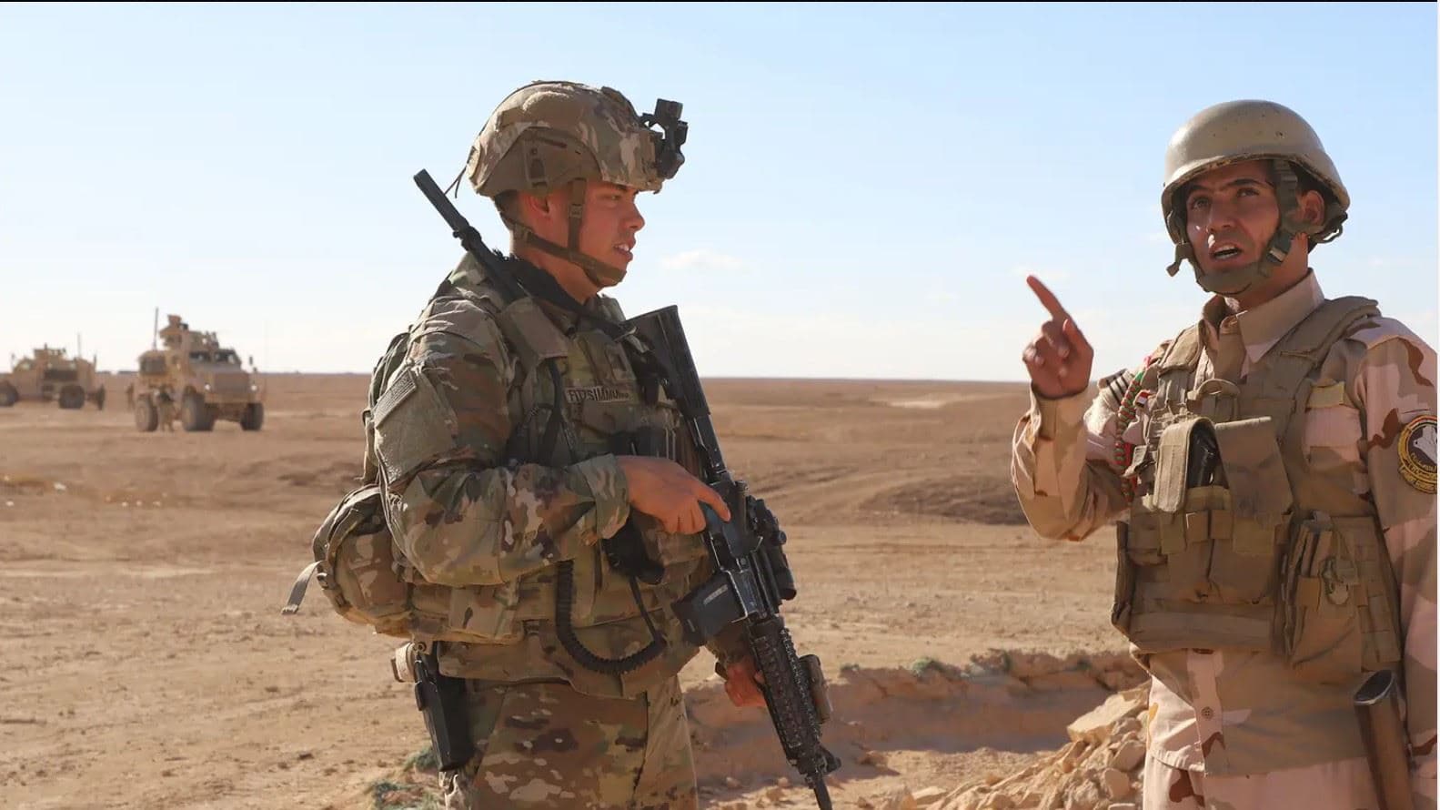 A US soldier [left] and an Iraqi soldier [right] speak with one another at al-Assad air base in western Iraq on December 21, 2021. Photo: US army 