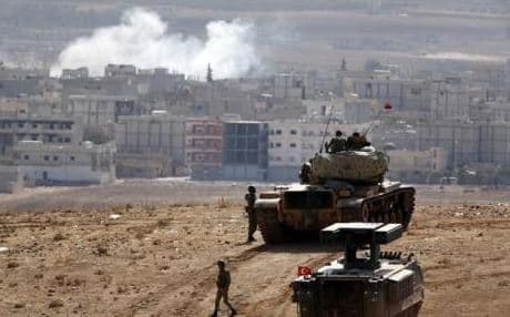 Turkish tanks watch Syrian Kurds battle ISIS from the border.
