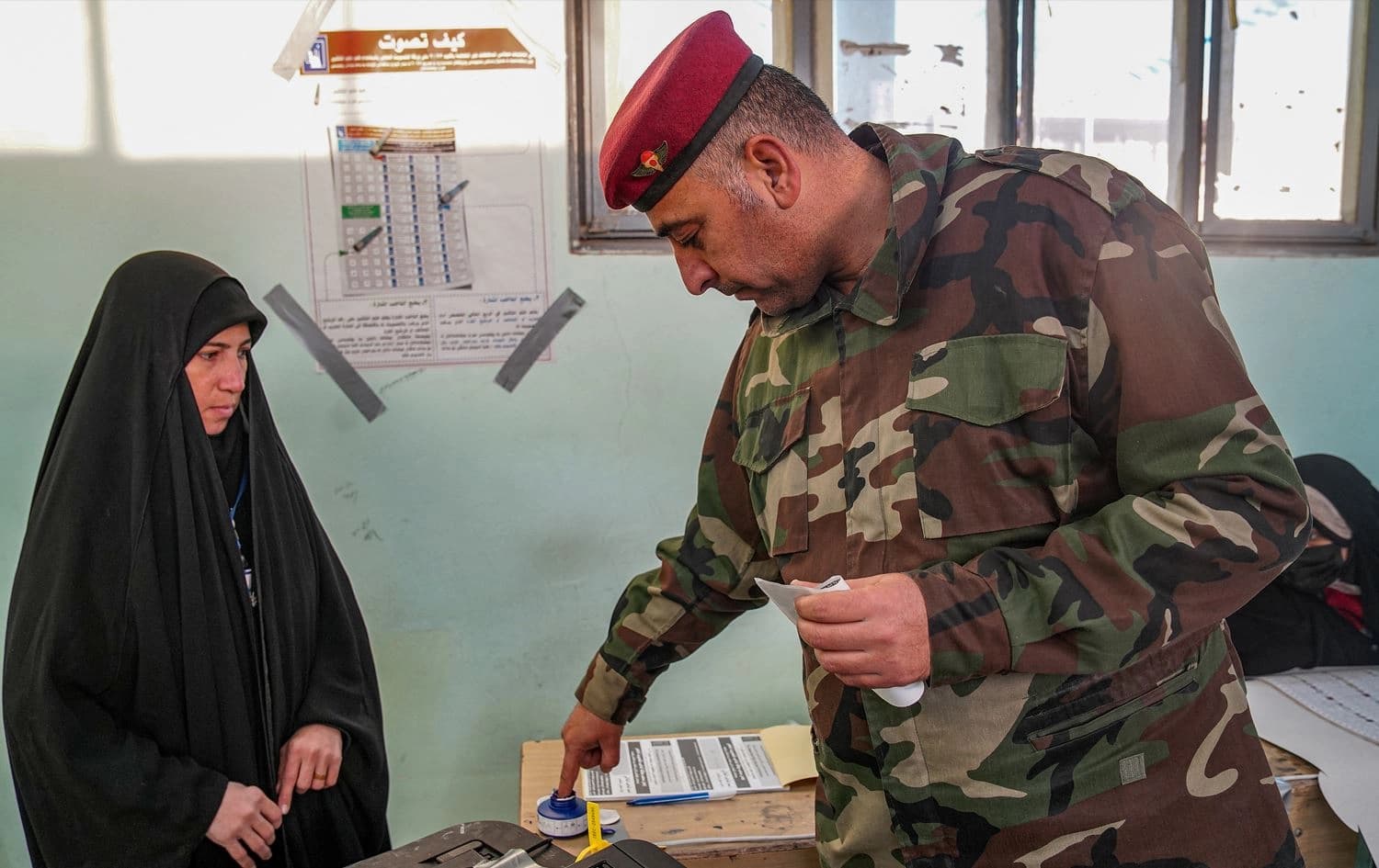 An Iraqi security officer dips his finger in ink after voting in the early round of the 2023 Iraqi provincial elections, in the central city of Najaf early on December 16, 2023. Photo: Qassem al-Kaabi/AFP