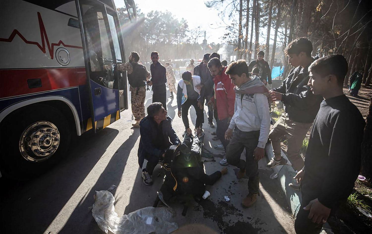 An injured man receives assistance following two explosions near the gravesite of slain Iranian commander Qasem Soleimani in Iran's Kerman on January 3, 2024. Photo: AFP