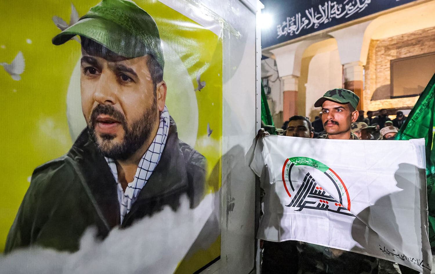 A member of PMF holds the group's flag while standing before the vehicle carrying the body of the group's slain commander Mushtaq Talib al-Saeedi during the funeral in Baghdad on January 4, 2024. Photo: AFP