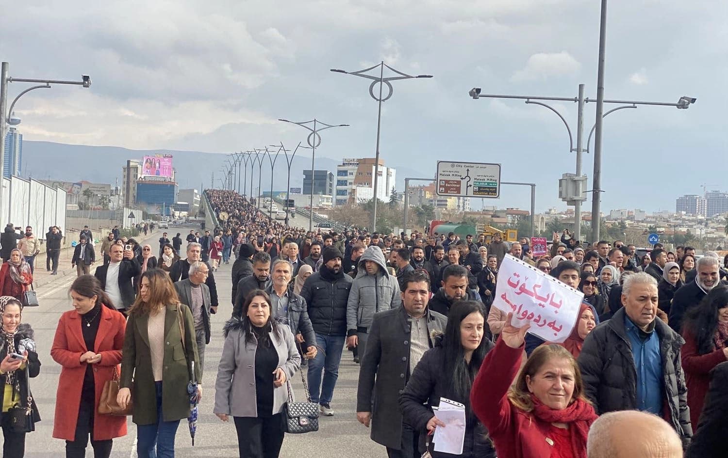 A teacher in Sulaimani holds a paper reading "Strike continues," during teacher's strike on January 21, 2024. Photo: Rudaw