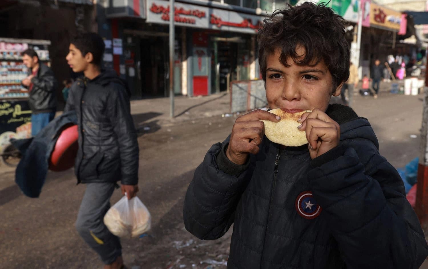 منداڵێک لە غەززە پارچەیەک نان دەخوات. وێنە:  AFP