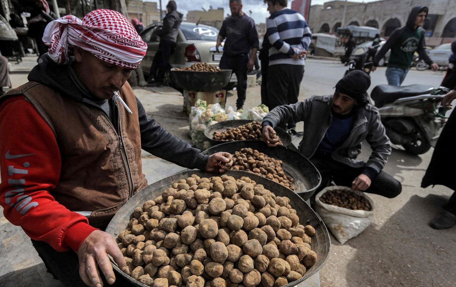 A merchant sorts through desert truffles at a stall in a market in the city of Hama in west-central Syria on March 6, 2023. Photo: Louai Beshara/AFP