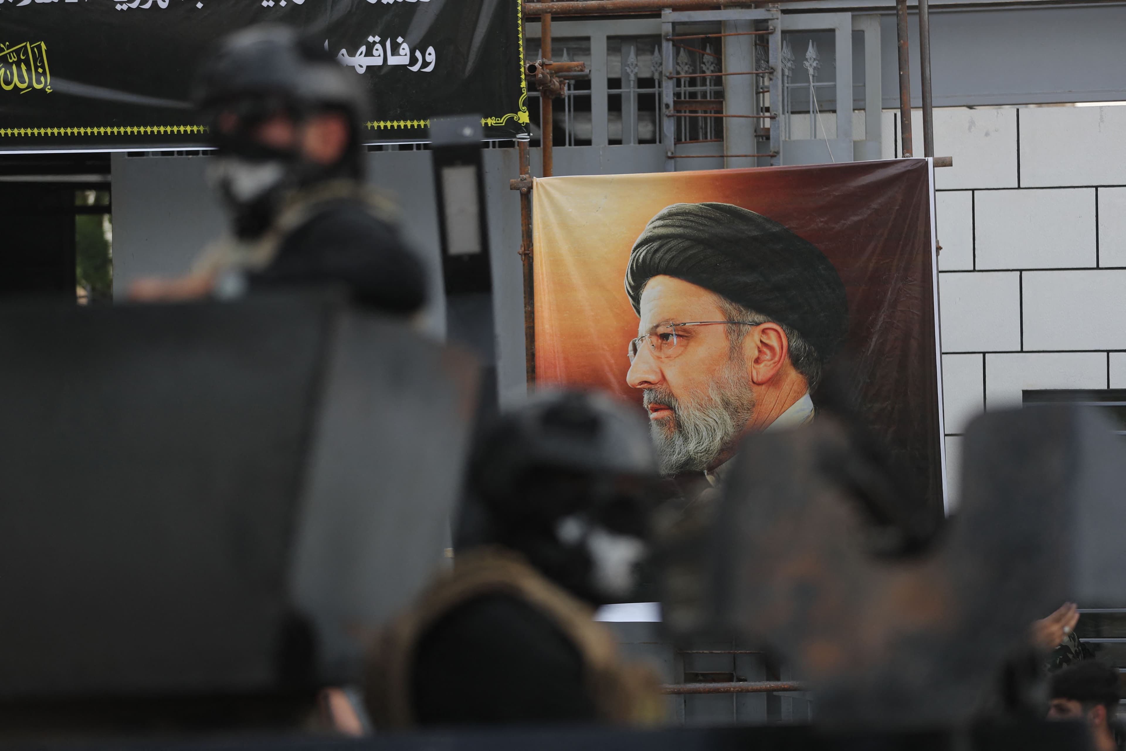 Iraqi security forces stand guard in front of a huge portrait of Iran's late president Ebrahim Raisi outside the Iranian embassy in Baghdad on May 20, 2024. Photo: AFP