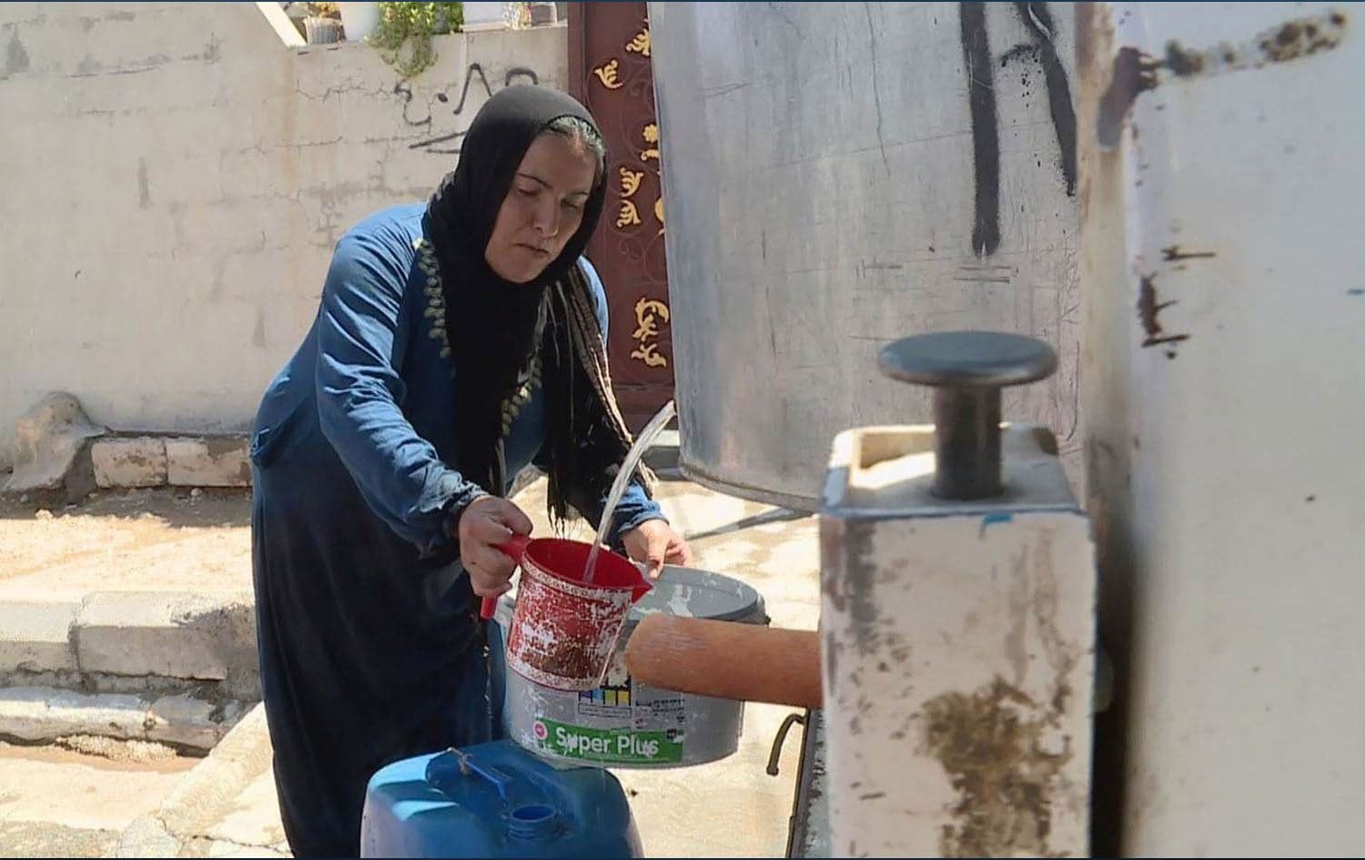 A woman in Chamchamal collecting water in bucket. File photo: Rudaw