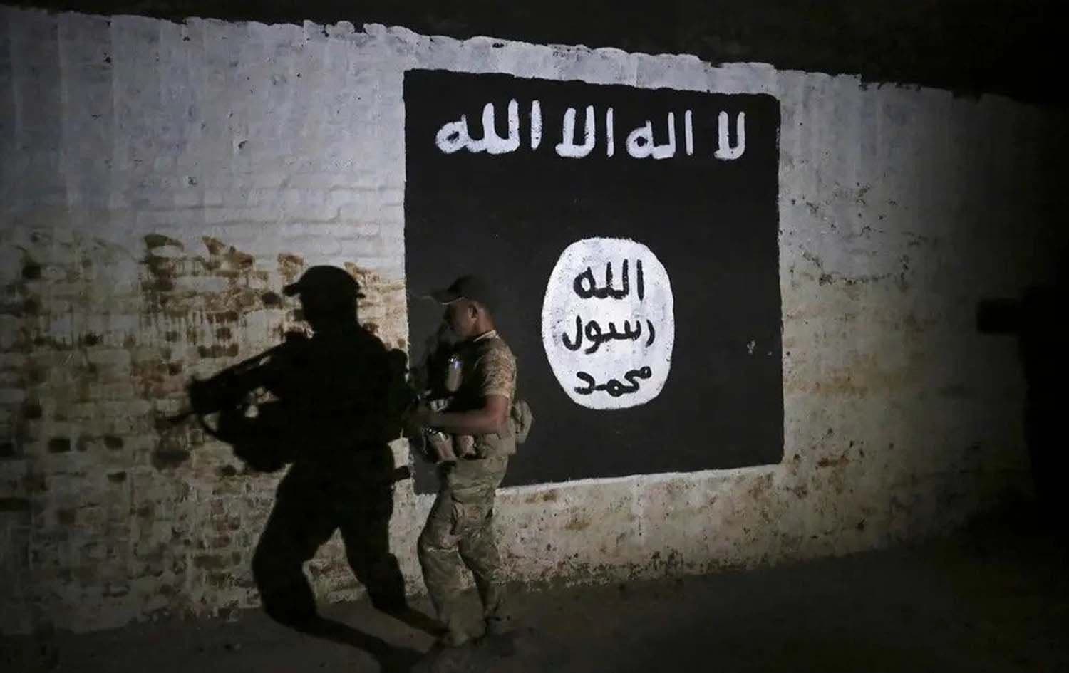 An Iraqi soldier inspects a train tunnel, adorned with an ISIS group flag. File photo: AP