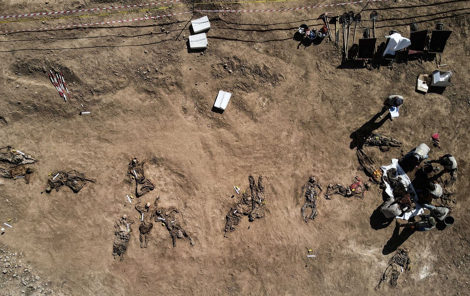 This aerial view taken on 13 June 2021 shows human remains, reportedly of victims of the 2014 Badush prison massacre committed by ISIS, after being unearthed from a mass grave in Nineveh. Photo: AFP