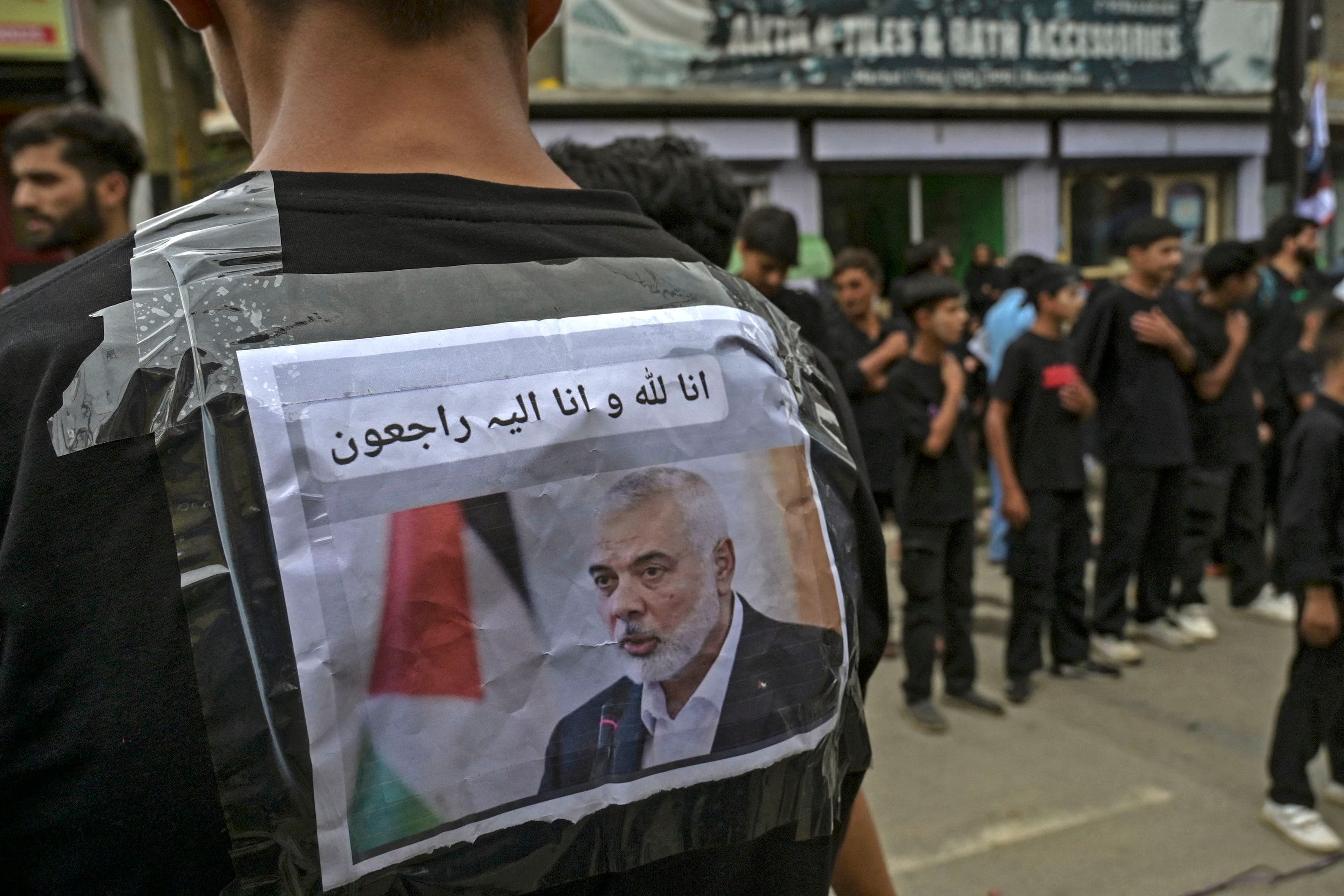 A photo of slain Hamas political chief Ismail Haniyeh is seen pasted on the back of a Shiite Muslim during 25th day of Muharram procession on the outskirts of Srinagar on August 1, 2024. Photo: AFP
