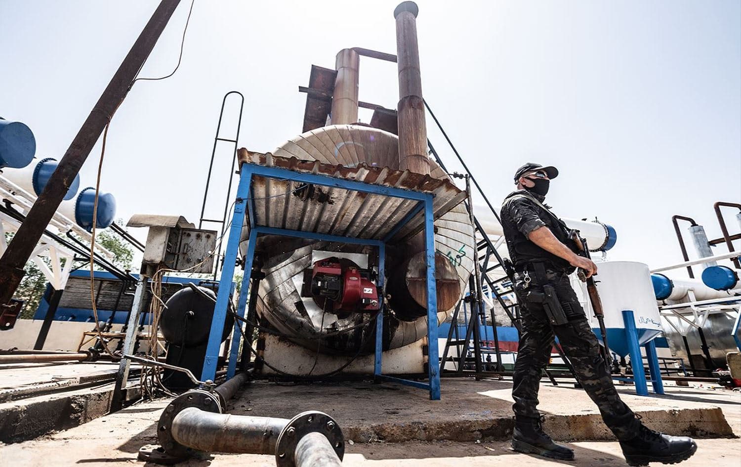 Local security standing in front of a closed oil refinery in Erbil on June 16, 2020. Photo: Billind T. Abdullah/Rudaw