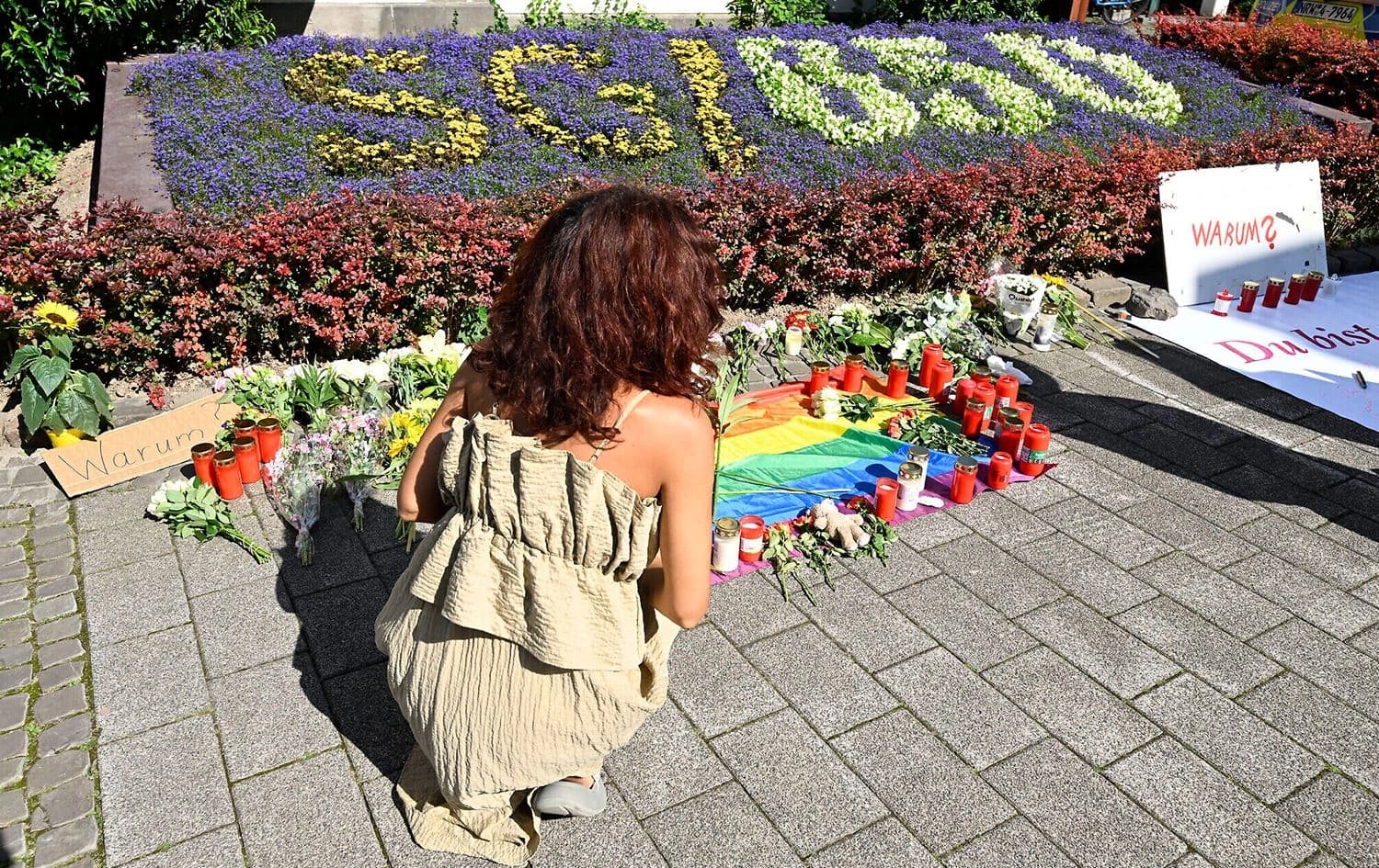A person lays flowers at a makeshift memorial on August 24, 2024, near the area where at least three people were killed in Solingen, Germany. Photo: Roberto Pfeil/AFP